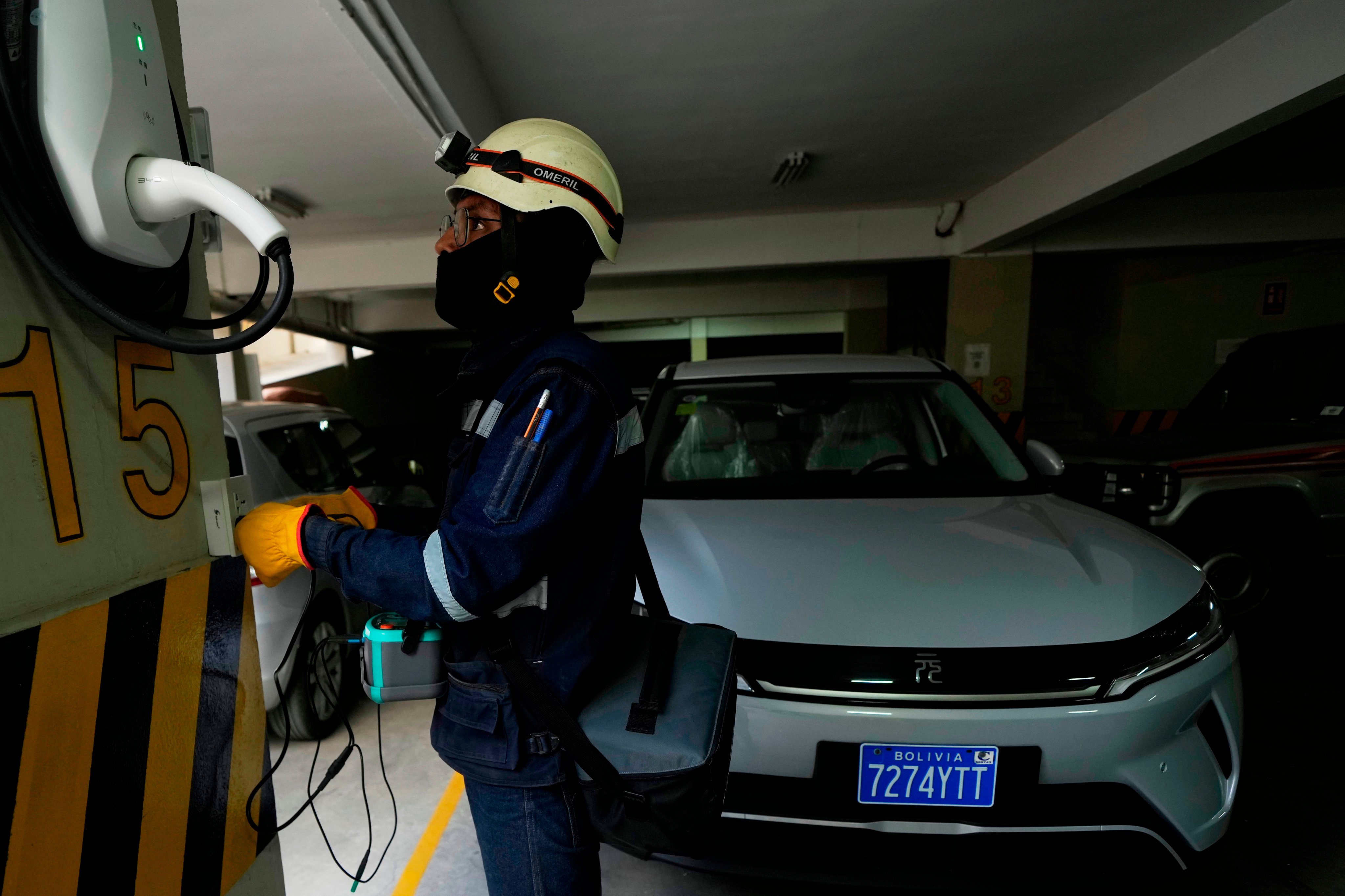 An electrician installs a home electric vehicle charging station in La Paz, Bolivia, on April 21. Photo: AP