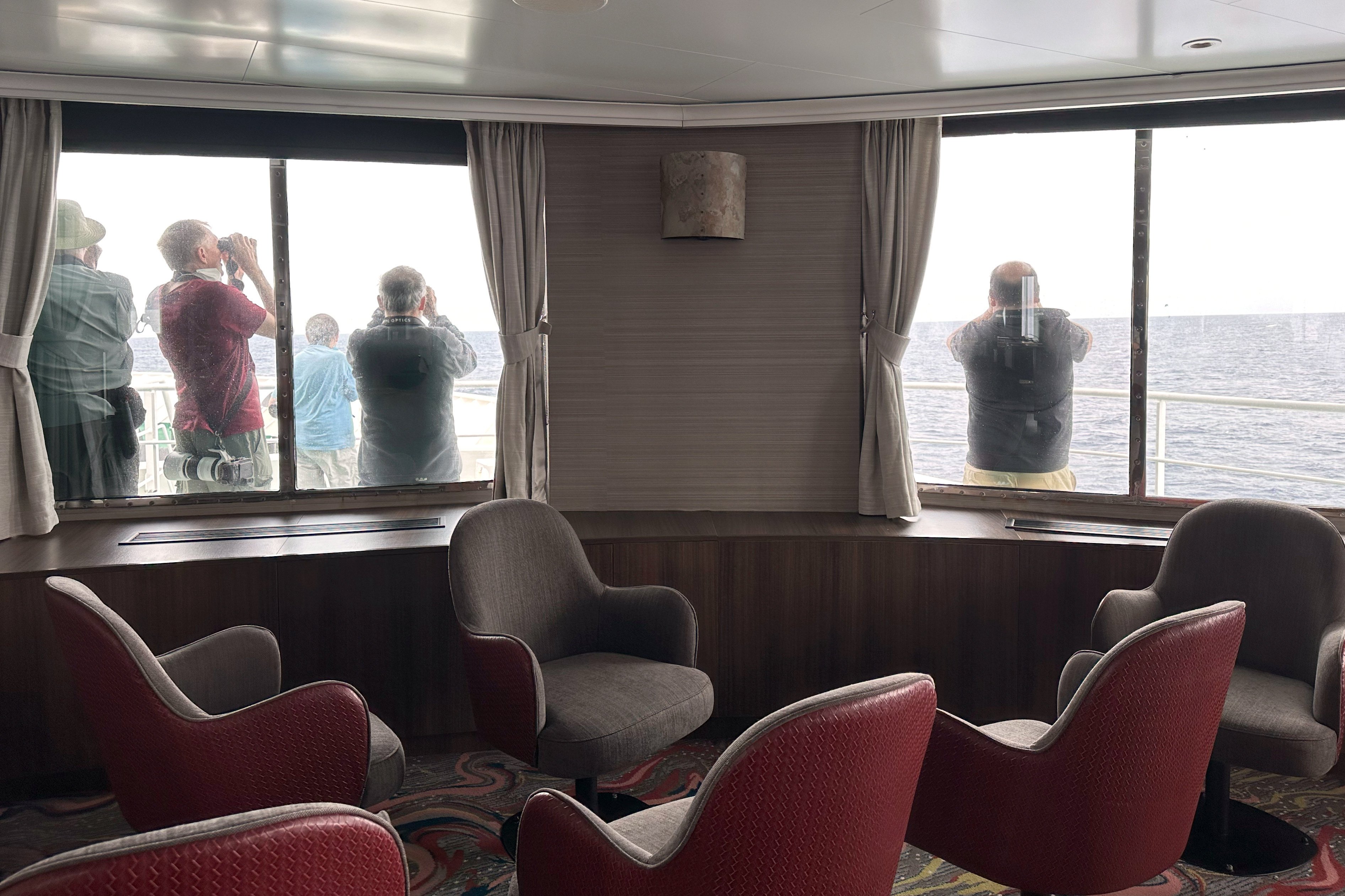 Passengers on the MV Hondius, scan the horizon with binoculars during their voyage to Spain’s port of Tenerife on  Wednesday. Photo: AP