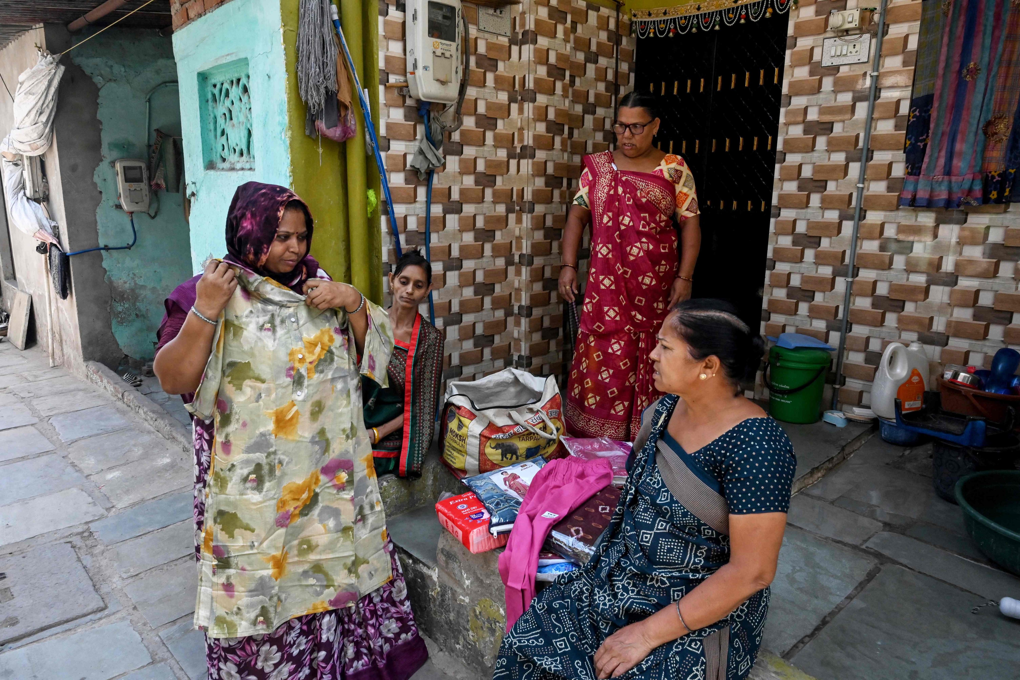 Lata Solanki (left) sells clothes door to door on April 28. Photo: AFP