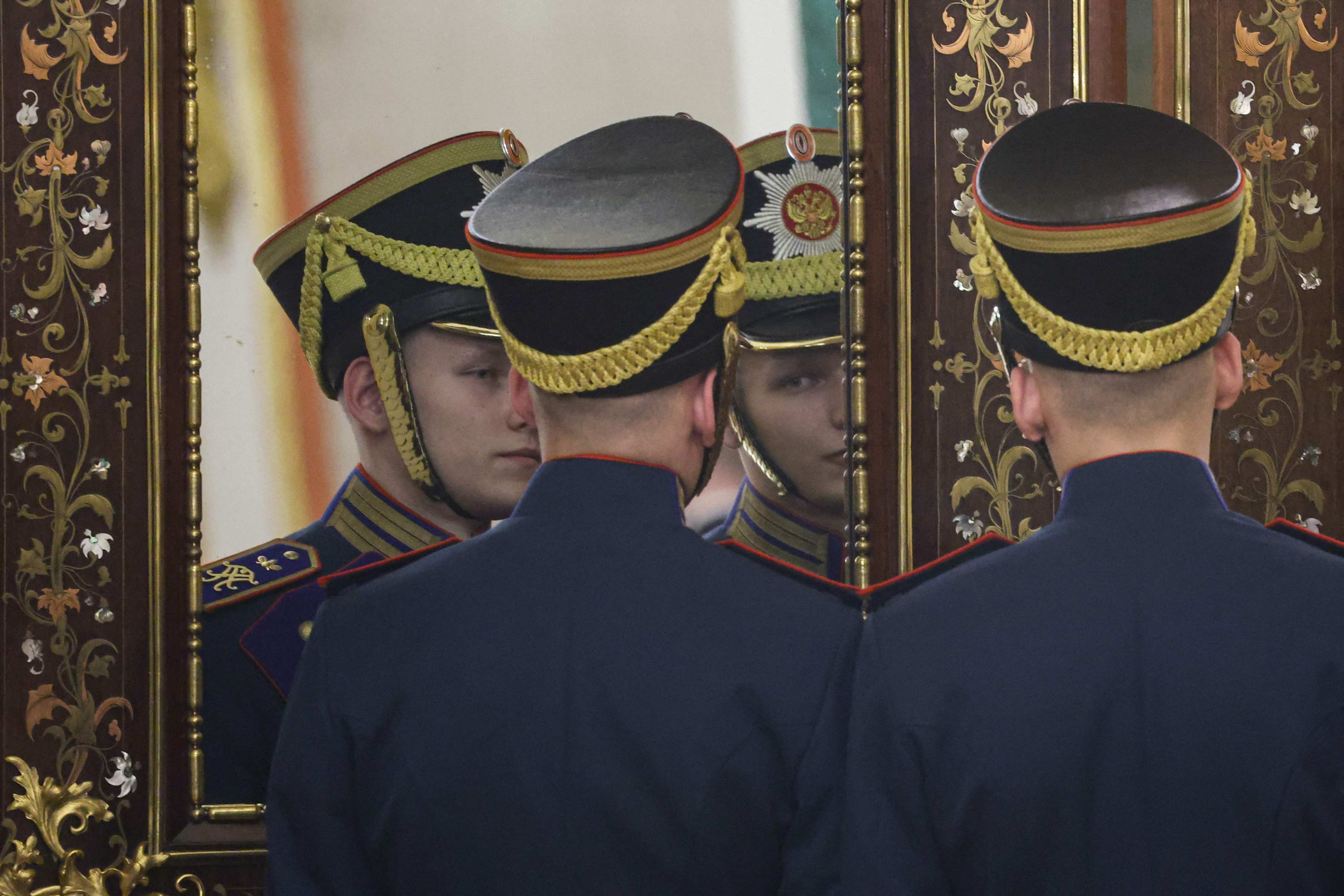 Russian honour guards adjust their uniforms in a mirror at the Kremlin. The UK has sanctioned 85 individuals and entities accused of Kremlin-funded 'information warfare'. Photo: AFP