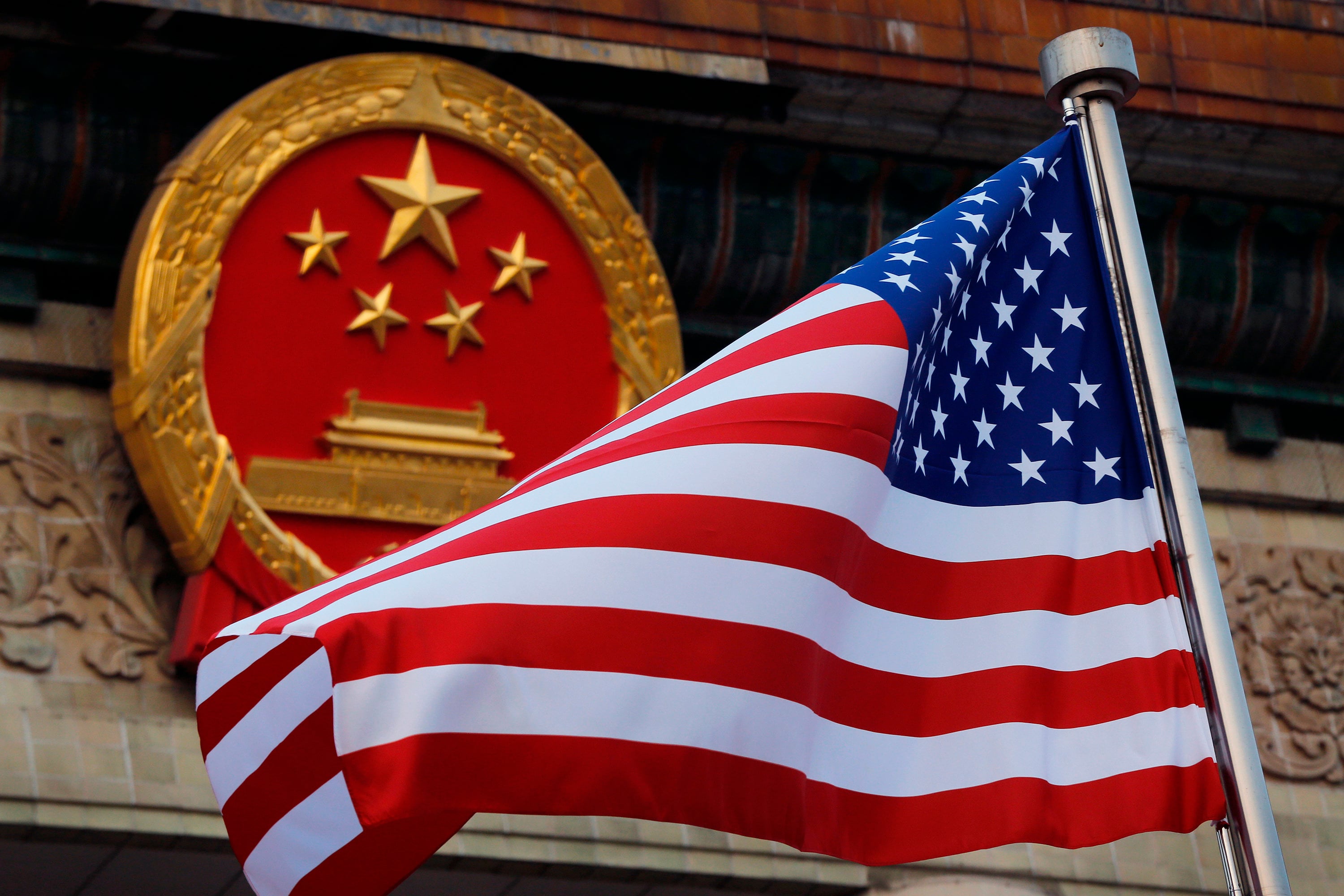 An American flag is flown next to the Chinese national emblem during a welcome ceremony for Trump’s last visit to China, outside the Great Hall of the People in Beijing on November 9, 2017. Photo: AP