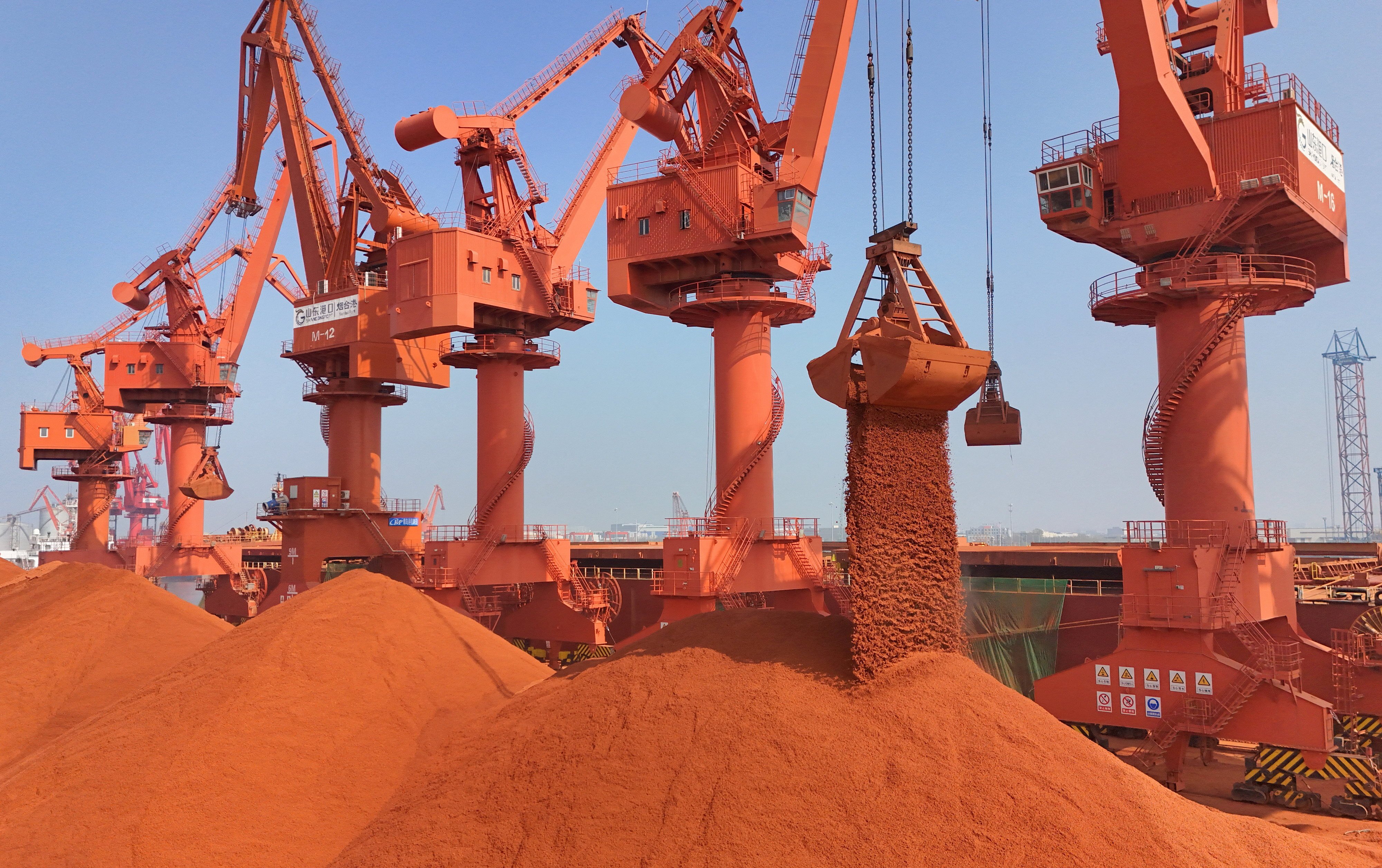 Cranes unload bauxite ore imported from Australia at a port in China’s eastern Shandong province. Photo: Reuters