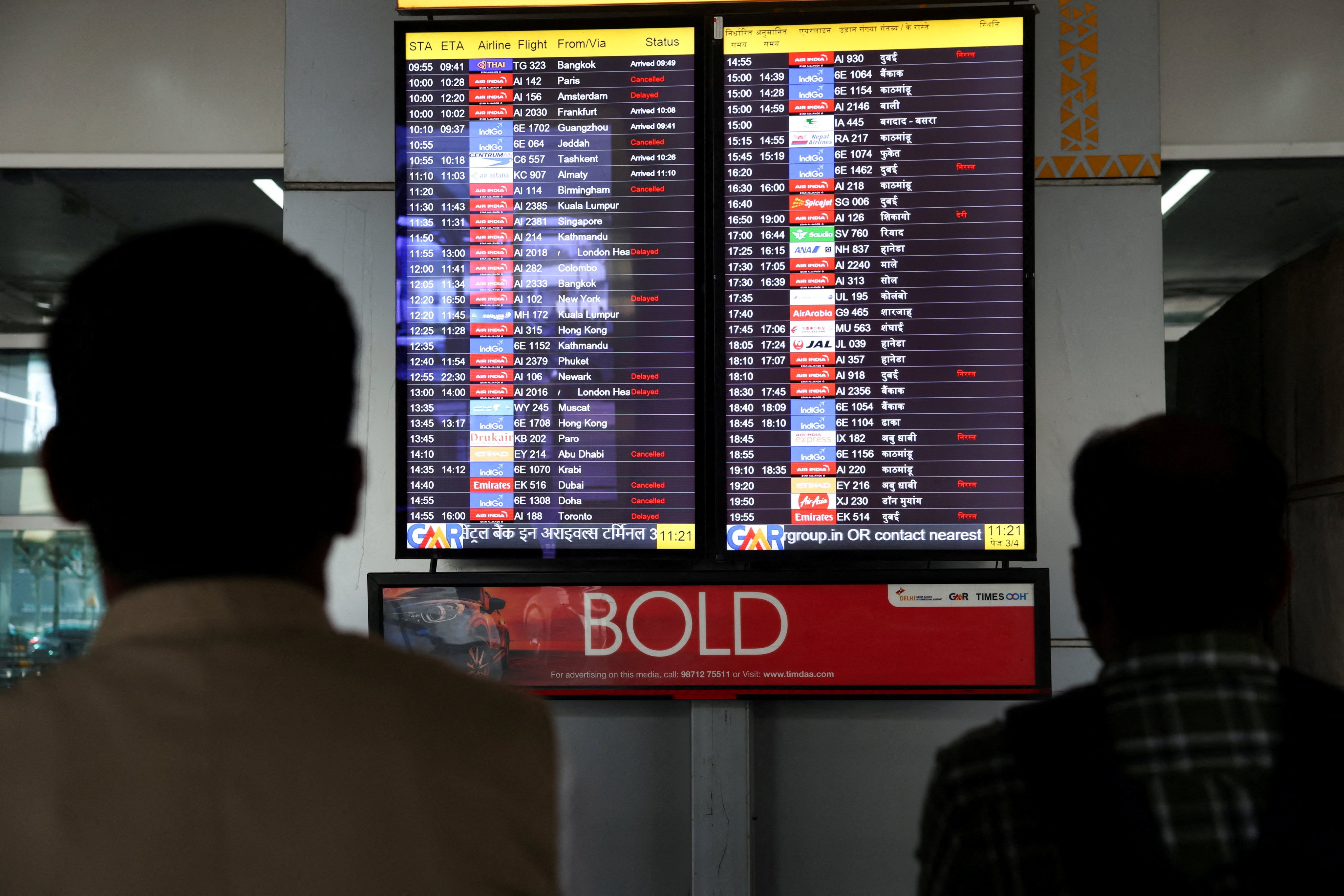 People look at a screen displaying flight information at the Indira Gandhi International airport in New Delhi on March 3. Photo: Reuters