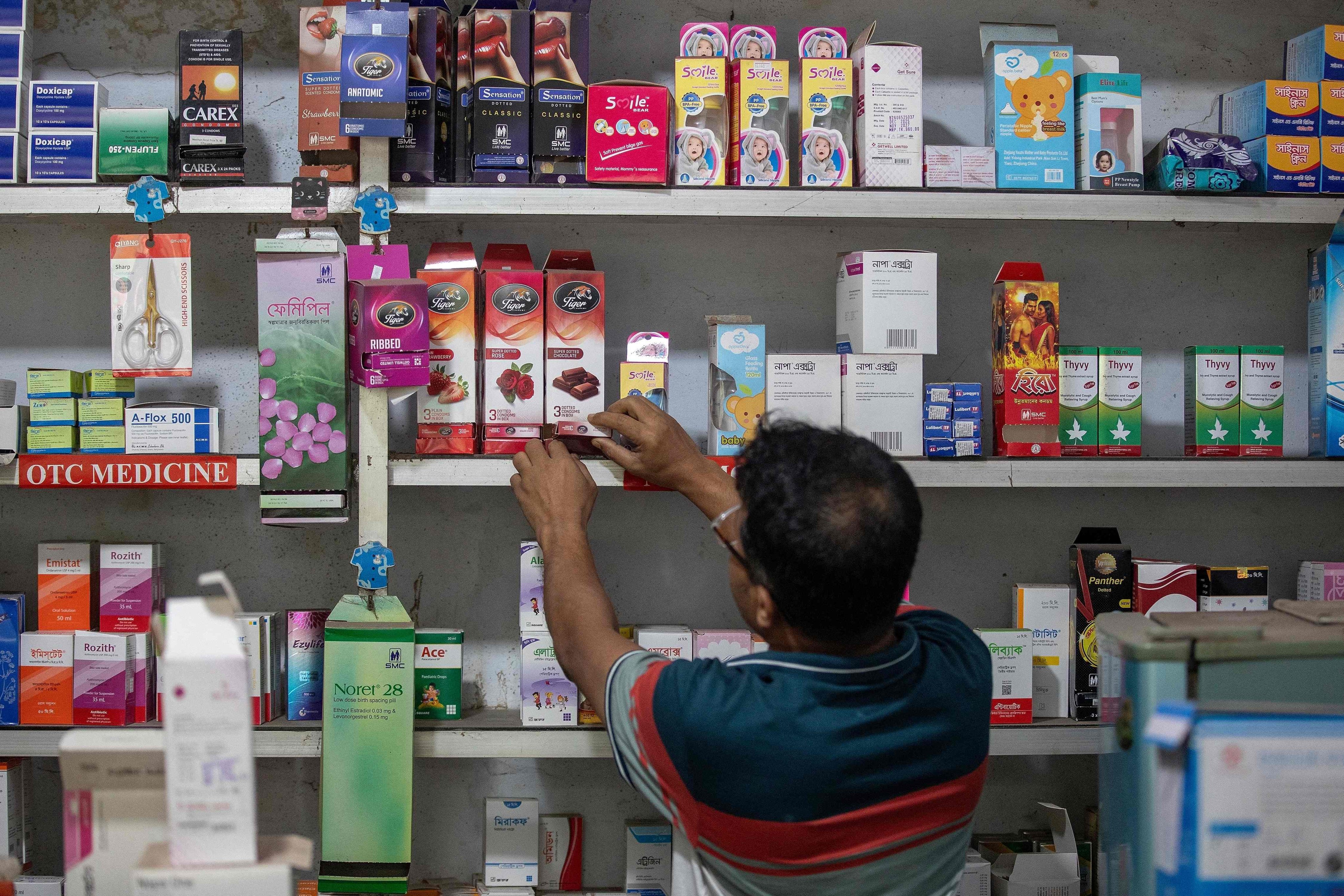 A pharmacy worker arranges packets of condoms in Dhaka on April 27. Photo: AFP