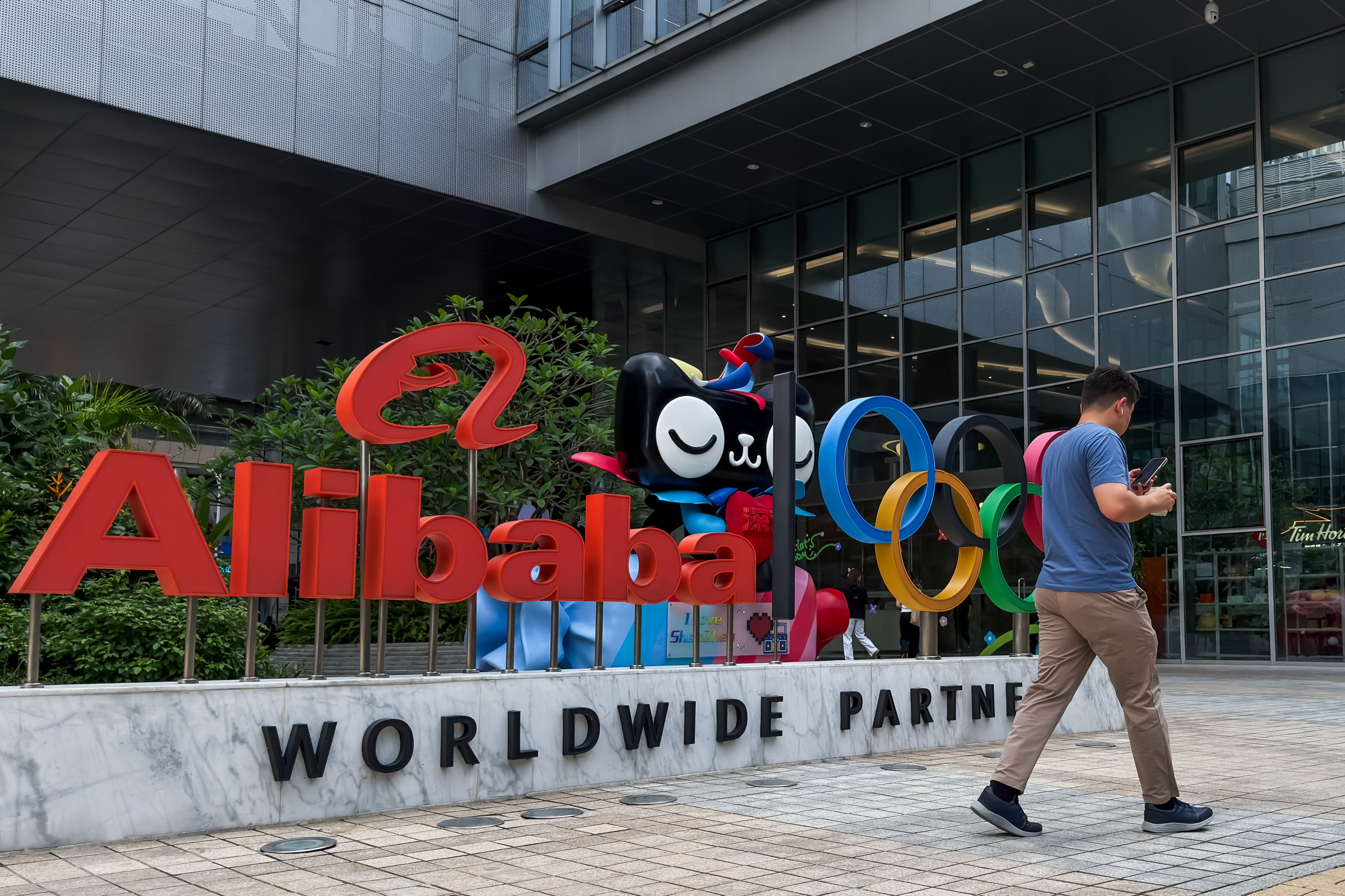 A man walks past an Alibaba display featuring the Olympic rings outside an Alibaba office building in Shenzhen, Guangdong province, on Tuesday. Photo: Getty Images