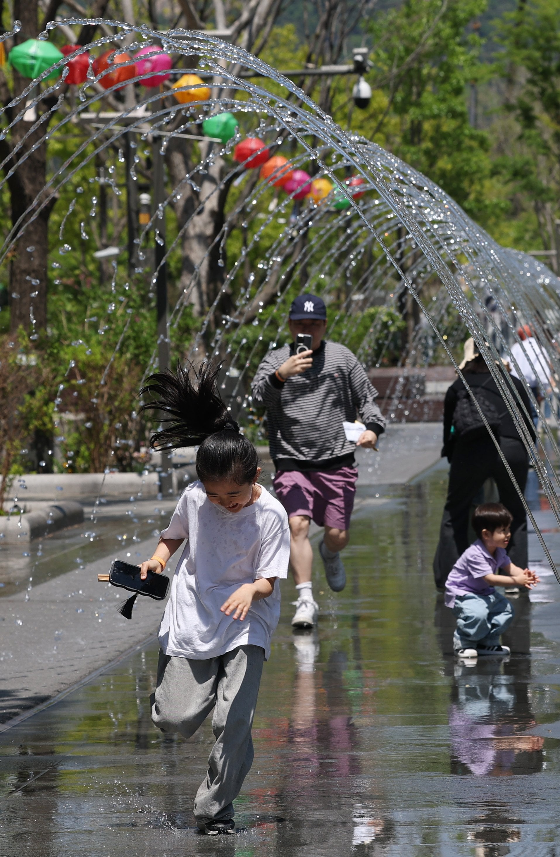 Children play in a fountain at Gwanghwamun Plaza in Seoul on April 26. Photo: Yonhap/EPA