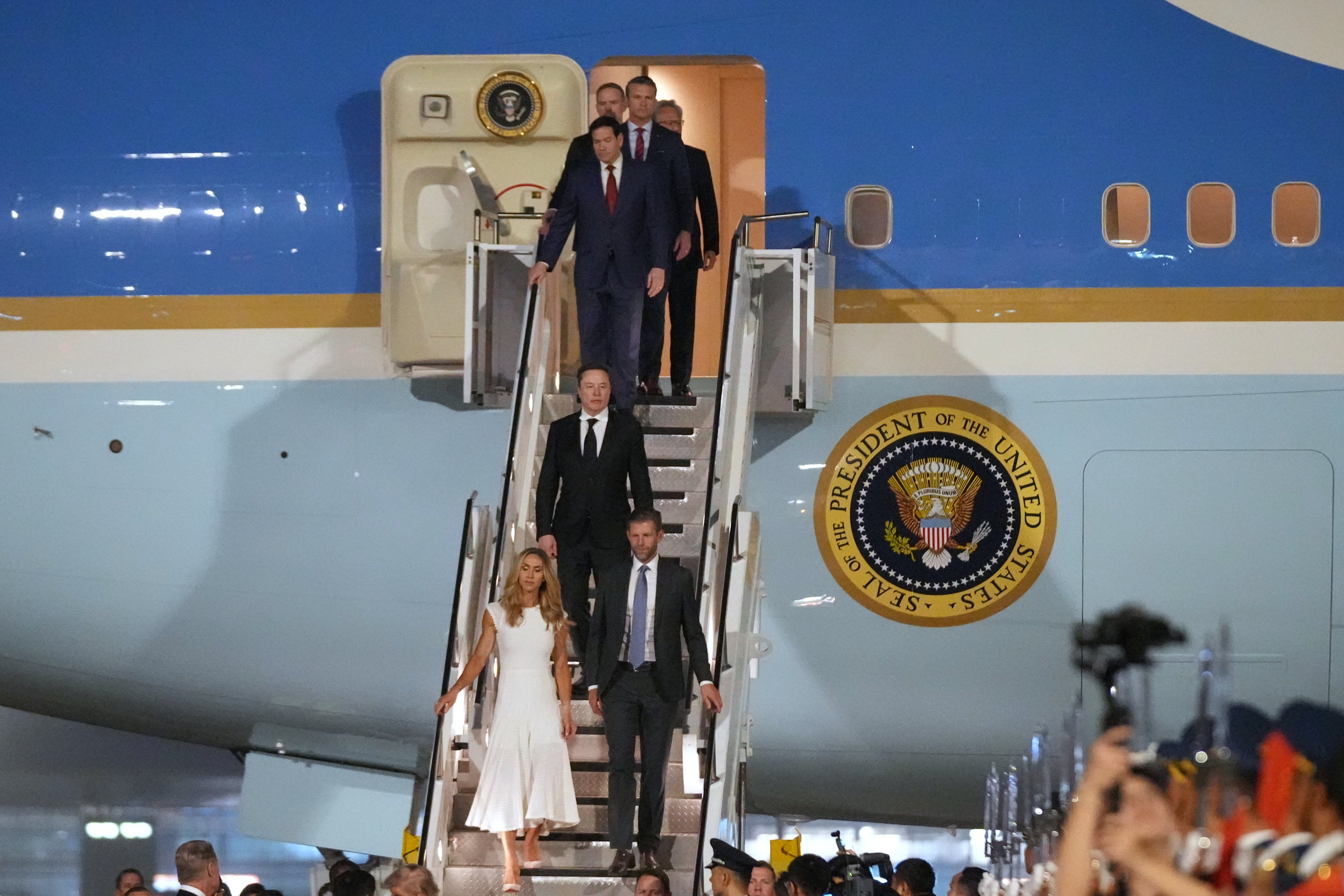Elon Musk follows Eric and Lara Trump down the stairs from Air Force One after its arrival at Beijing Capital International Airport on Wednesday night. Photo: AP