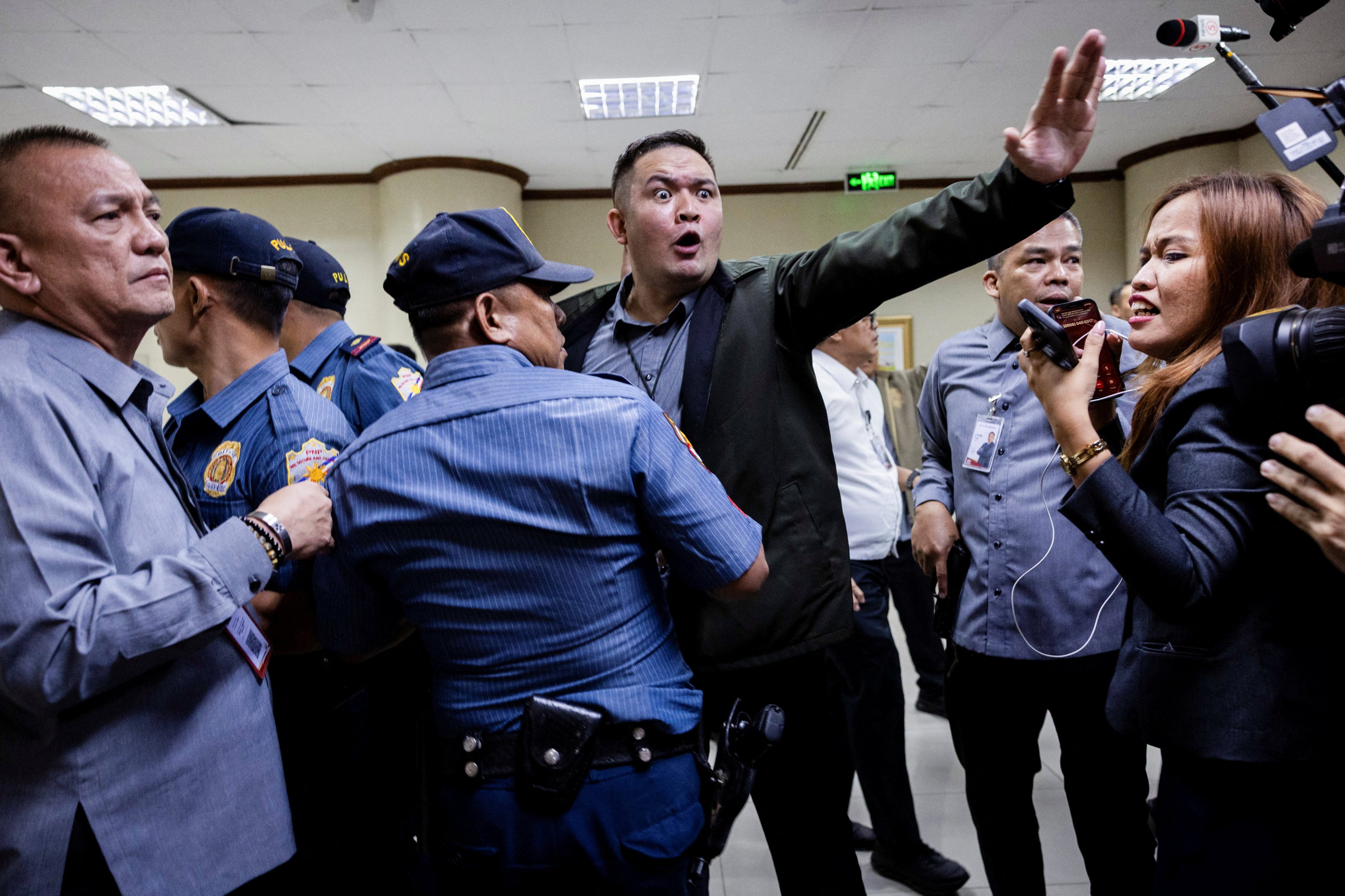 Senate security personnel and police officers ask members of the media to stay back after gunshots were heard at the Philippine Senate, as chaos mounted in anticipation of an attempt to arrest a top senator wanted by the International Criminal Court, in Pasay City, Metro Manila, Philippines, May 13, 2026. REUTERS/Eloisa Lopez