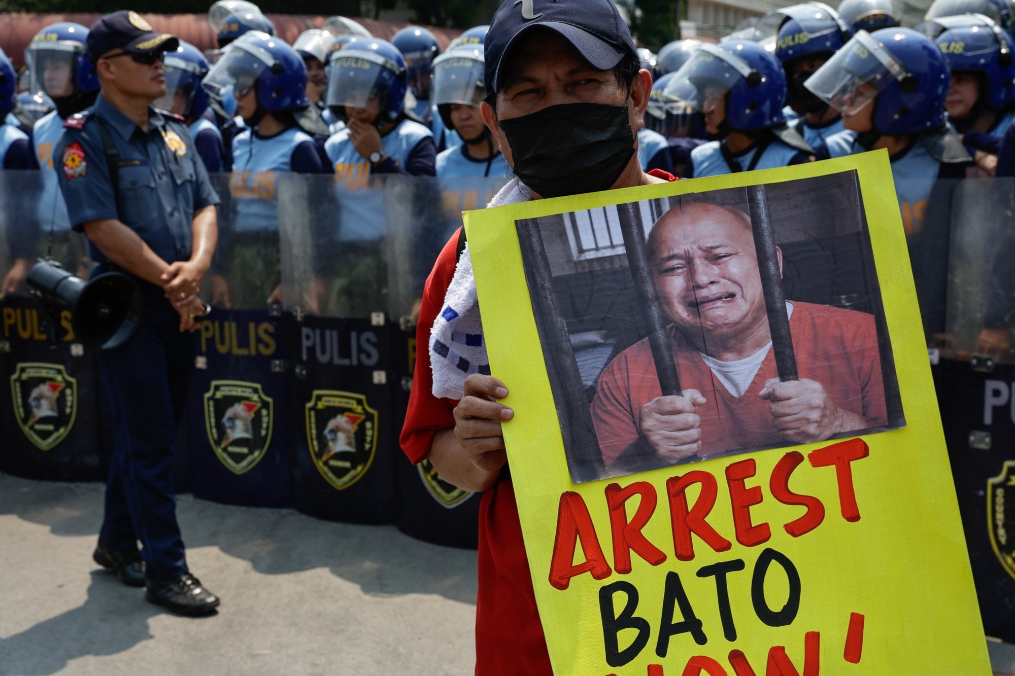 A protester holds a placard of Philippine Senator Ronald “Bato” dela Rosa during a rally calling for his arrest outside the Senate on Wednesday. Photo: EPA