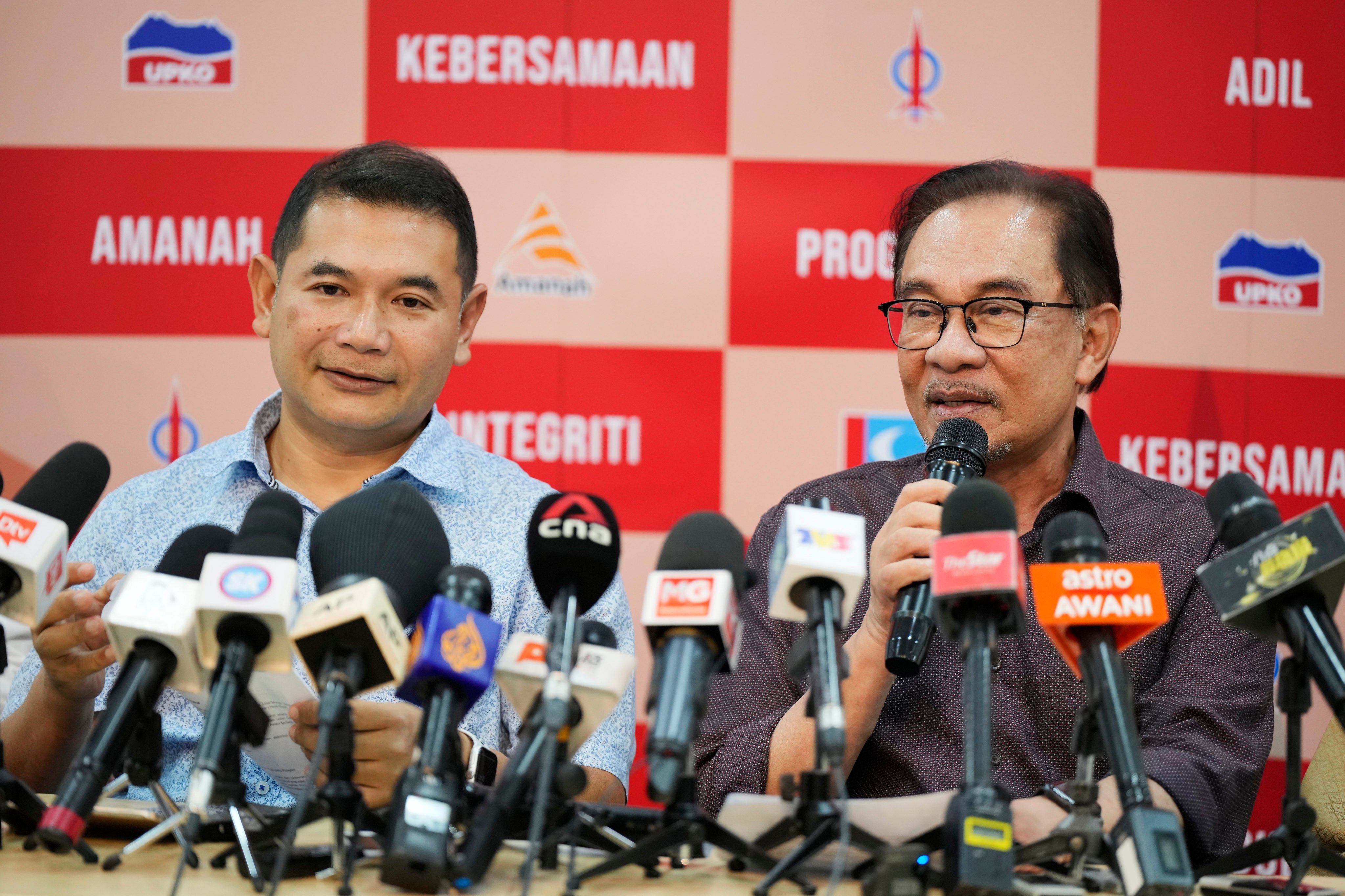 Rafizi Ramli accompanies Anwar Ibrahim as he speaks during a news conference on October 26, 2022. Photo: AP
