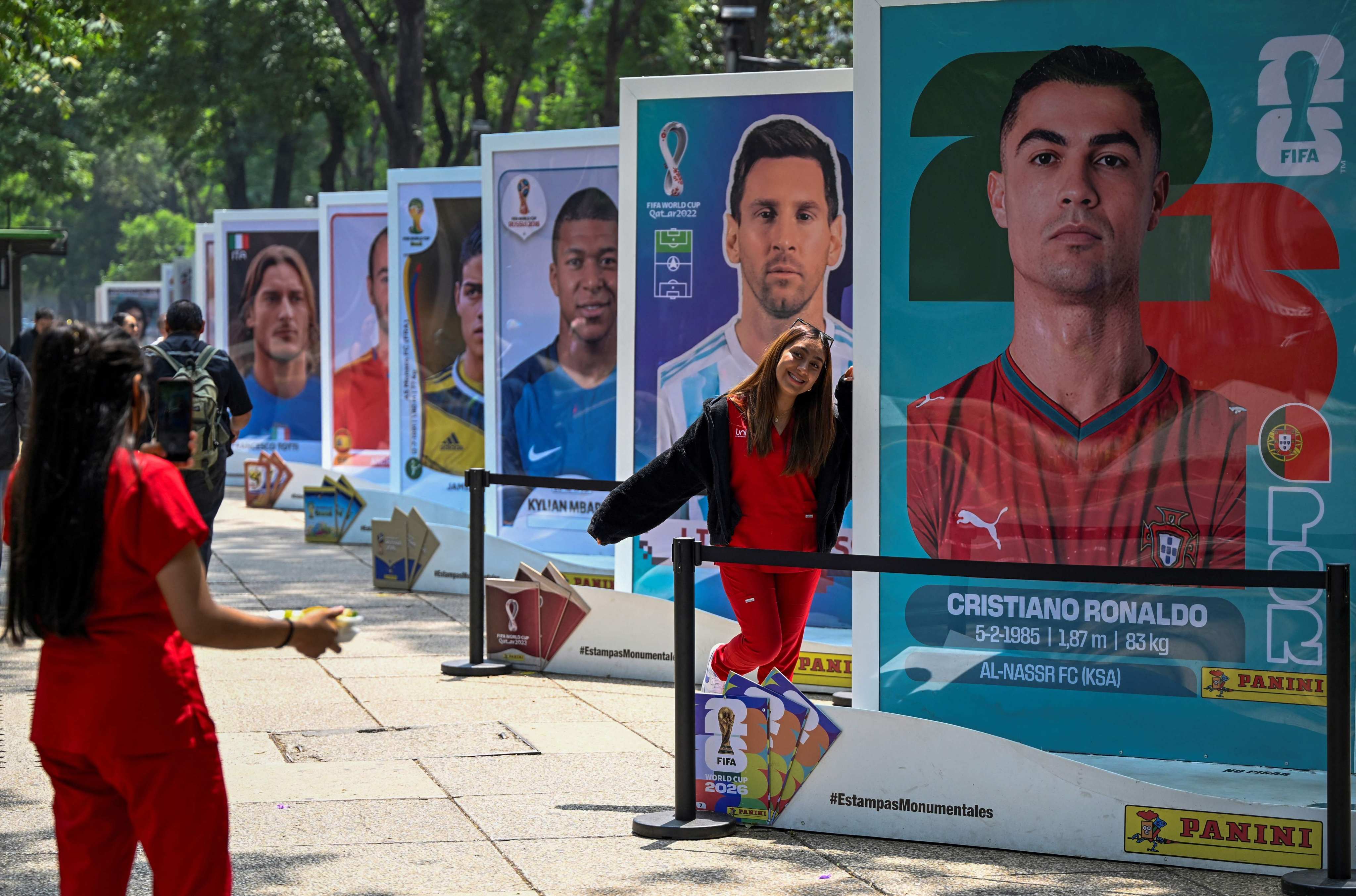 A woman poses with a picture of Portuguese footballer Cristiano Ronaldo during an exhibition of the Panini World Cup Album at Reforma Avenue in Mexico City. Photo: AFP