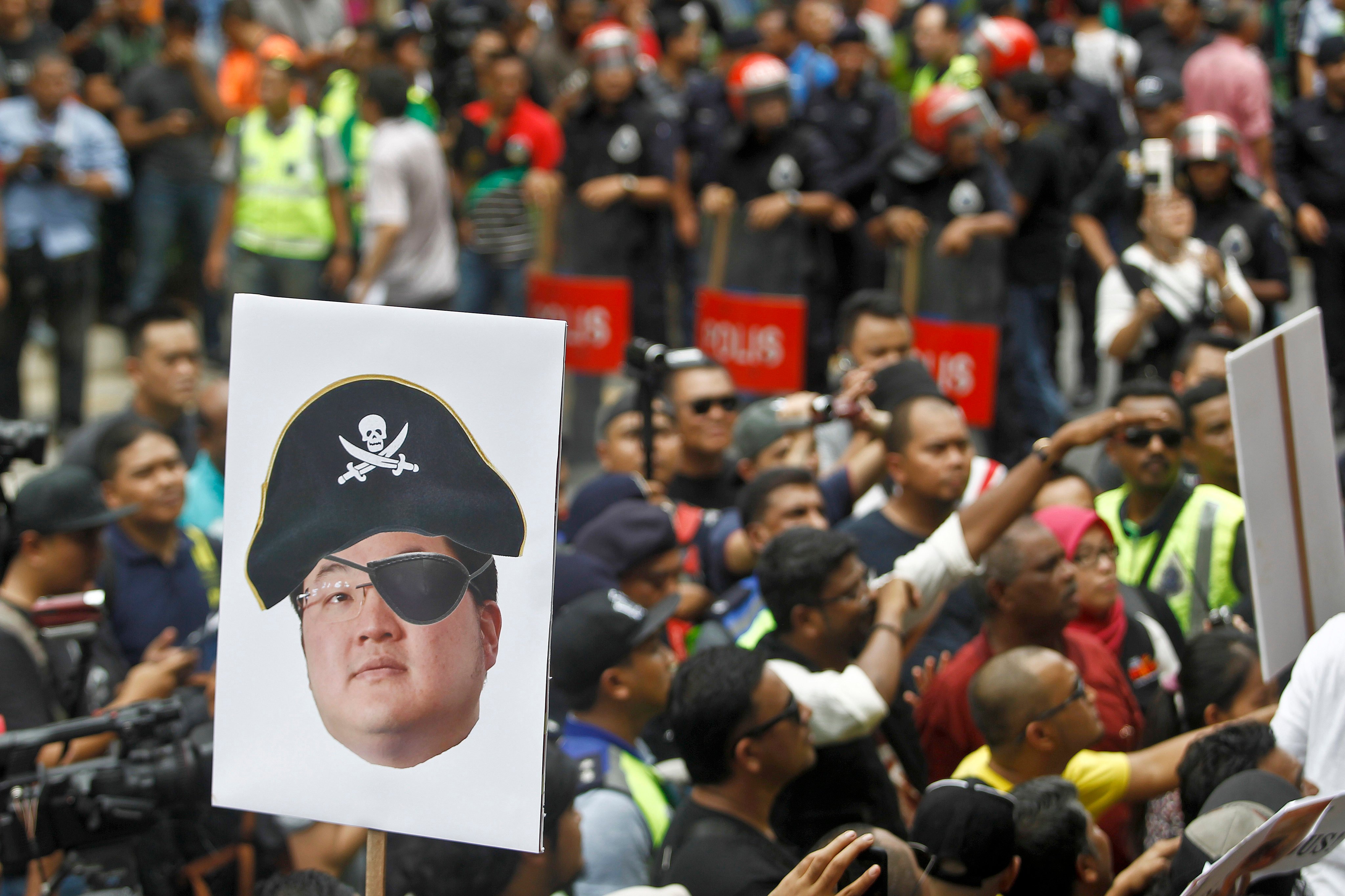 A protester holds a poster of Jho Low  as a pirate during a rally in Kuala Lumpur on April 14, 2018. Photo: AP