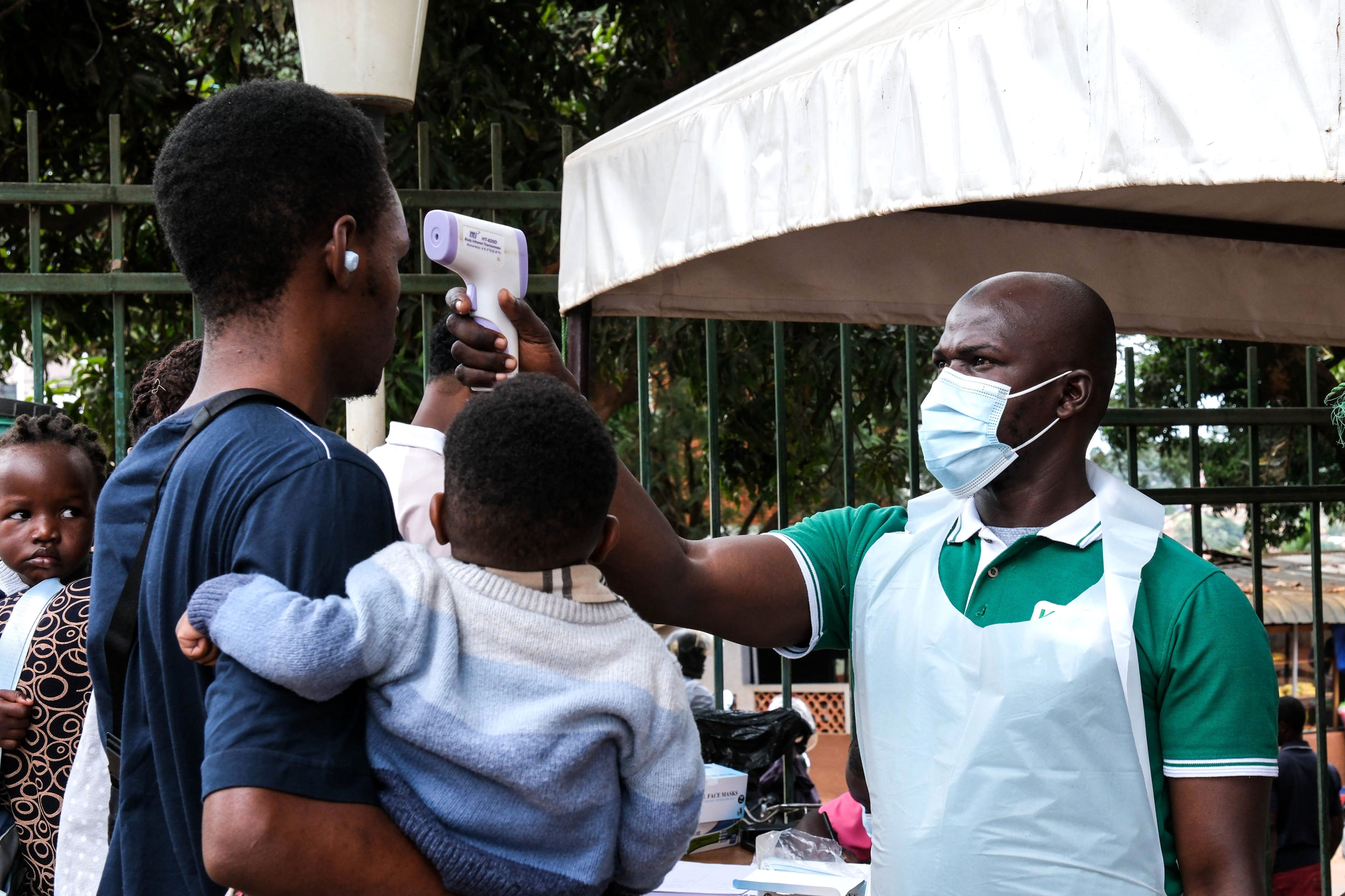 A health official uses a thermometer to screen people in front of Kibuli Muslim Hospital in Kampala, Uganda, on Saturday. Photo: AP