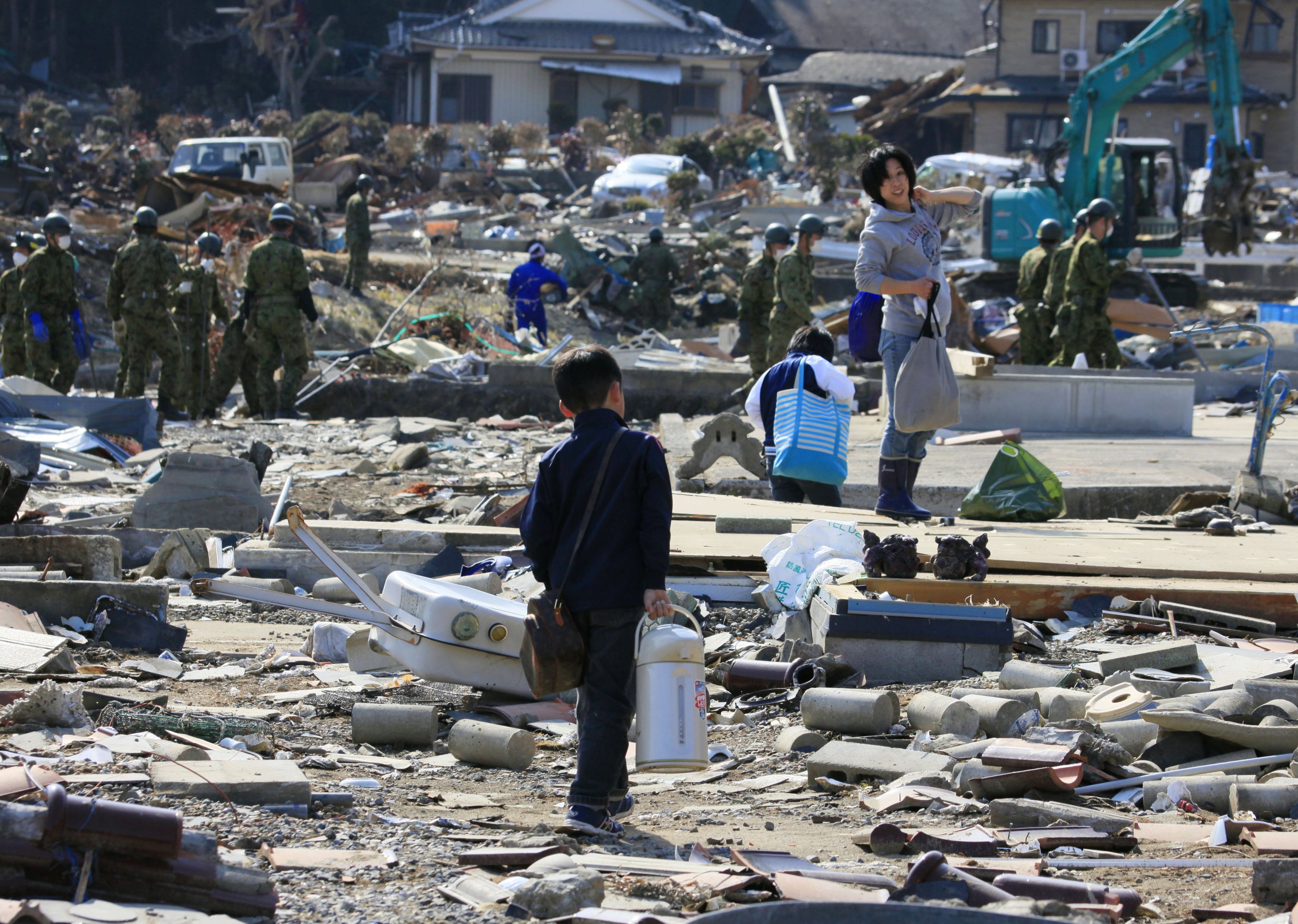 A family retrieve belongings from their destroyed home in Ishinomaki, Miyagi, Japan, on April 10, 2011. Photo: EPA