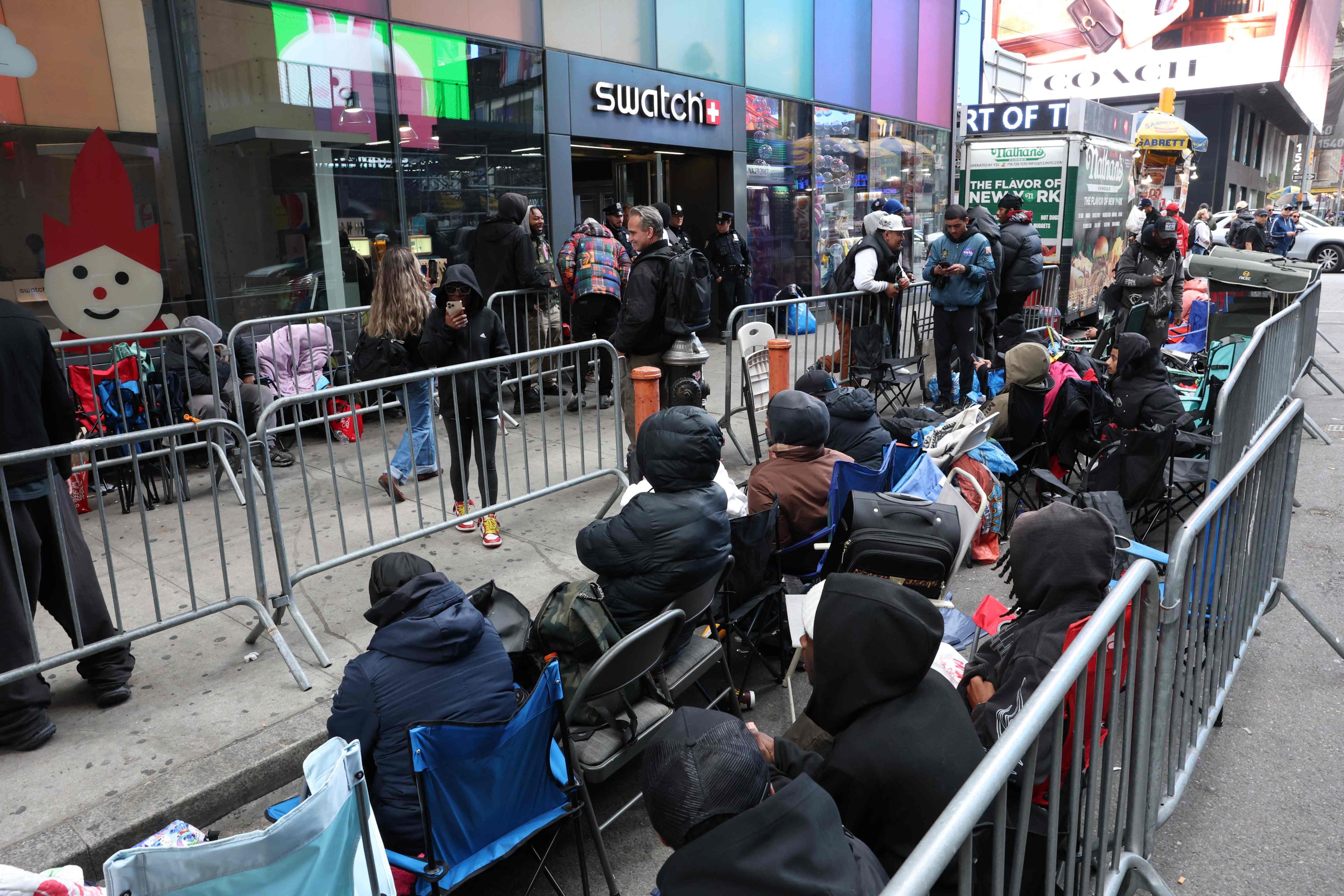 People wait outside the Swatch store in Times Square in New York on Friday. Photo: AFP