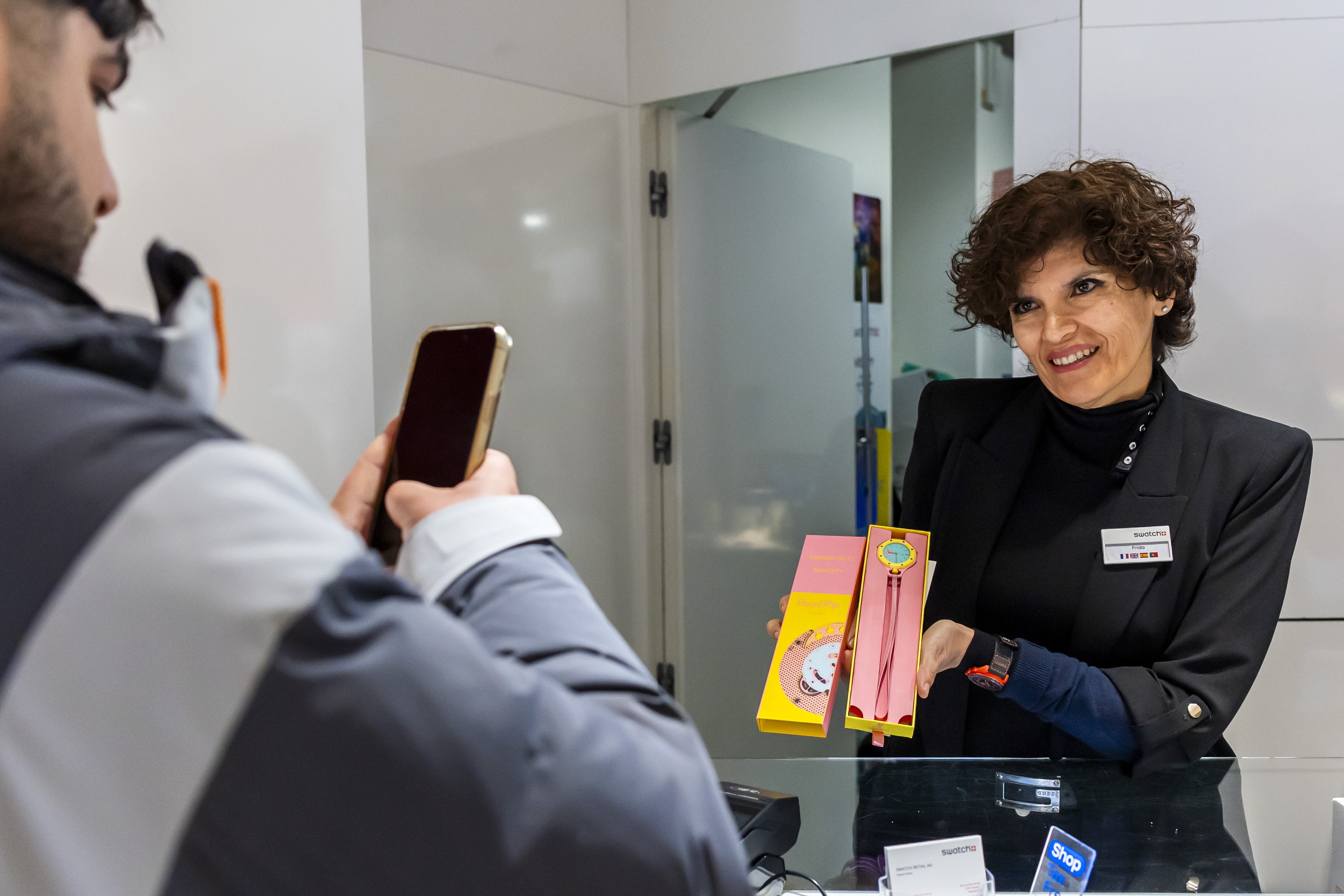 A saleswoman shows the new “Royal Pop” watch by Swatch and Audemars Piguet to a customer in Geneva. Photo: EPA