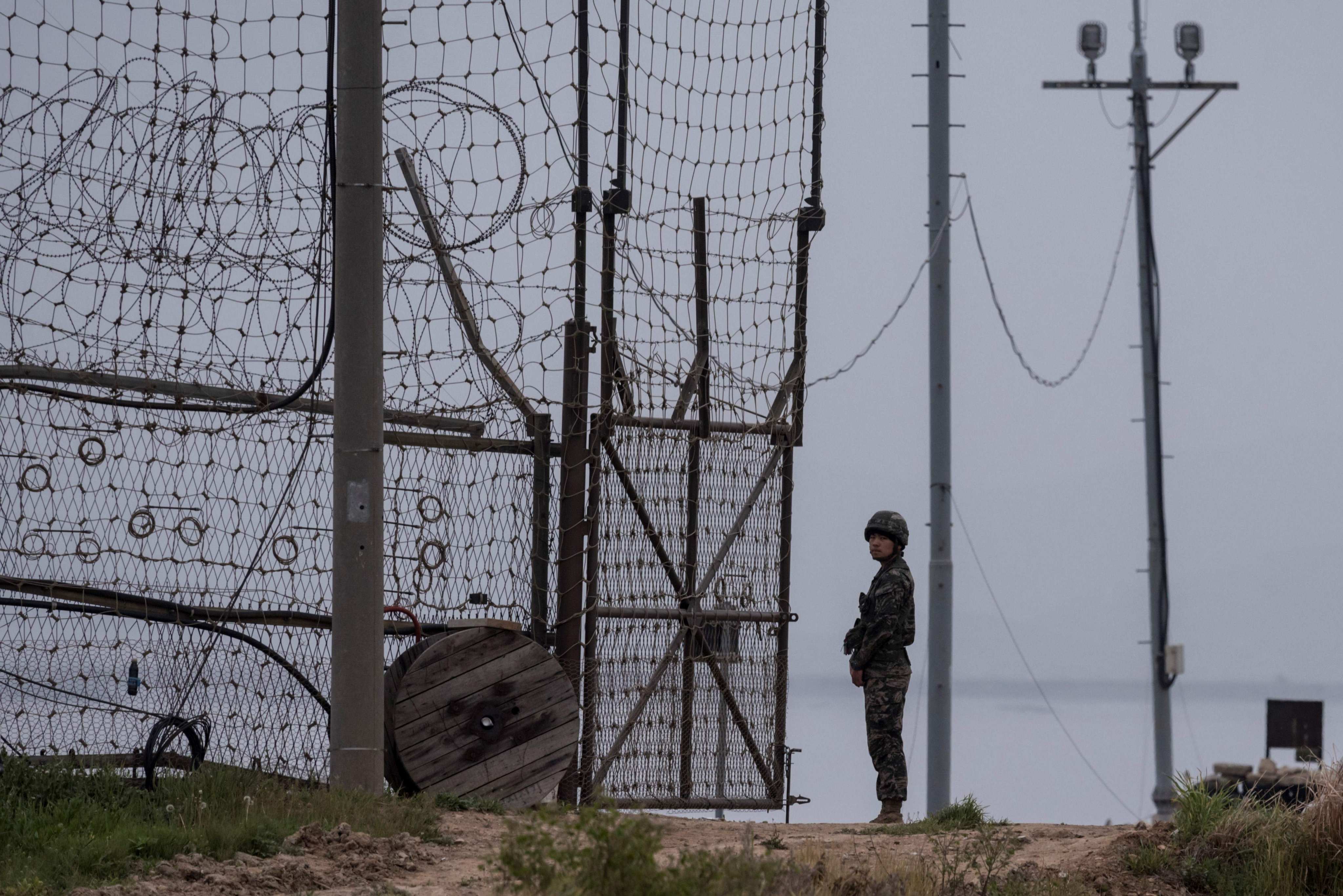 A soldier stands at a fence bordering the demilitarised zone (DMZ) separating North and South Korea in 2017. Photo: AFP