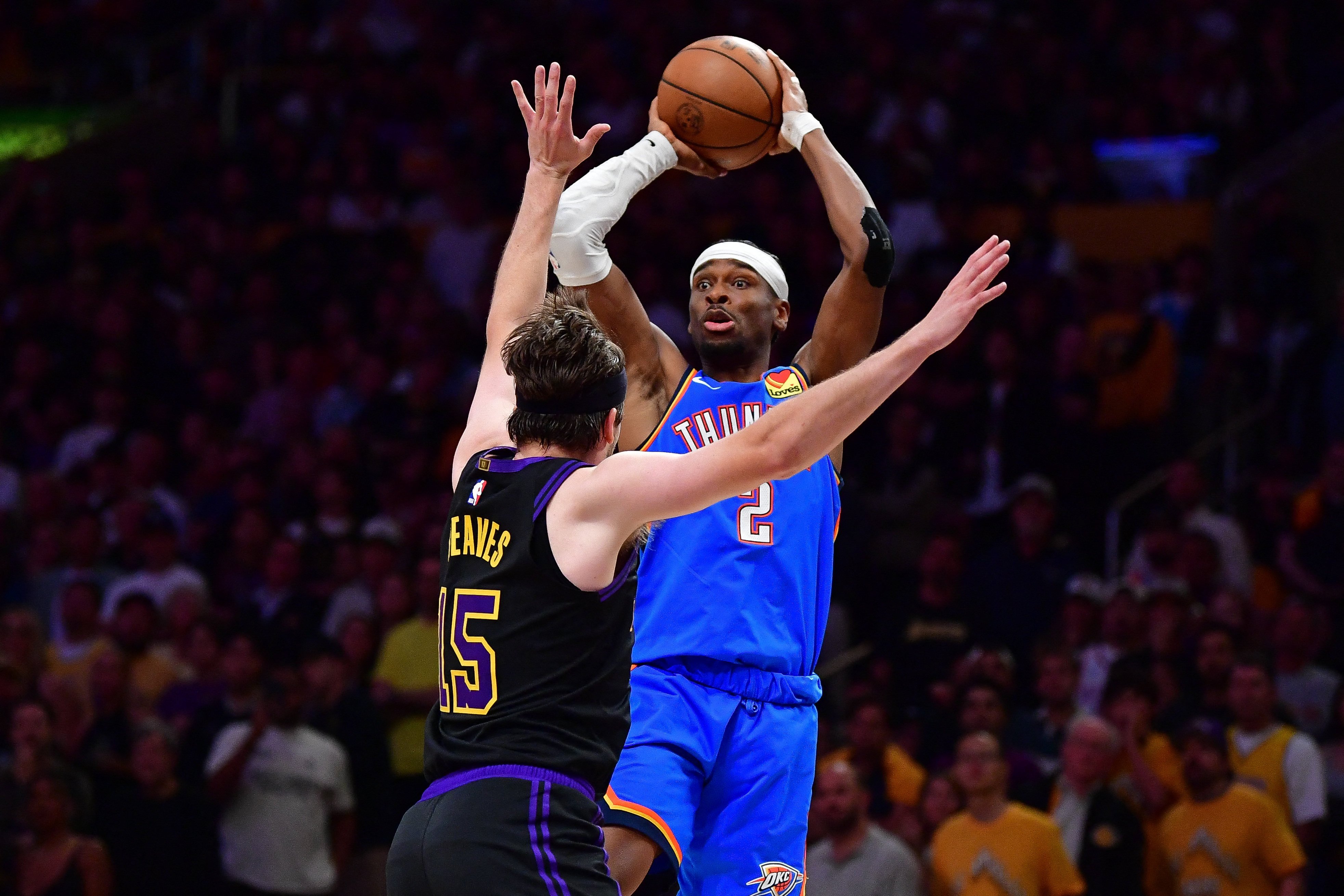 Oklahoma City Thunder guard Shai Gilgeous-Alexander passes the ball over Los Angeles Lakers counterpart Austin Reaves. Photo: Reuters