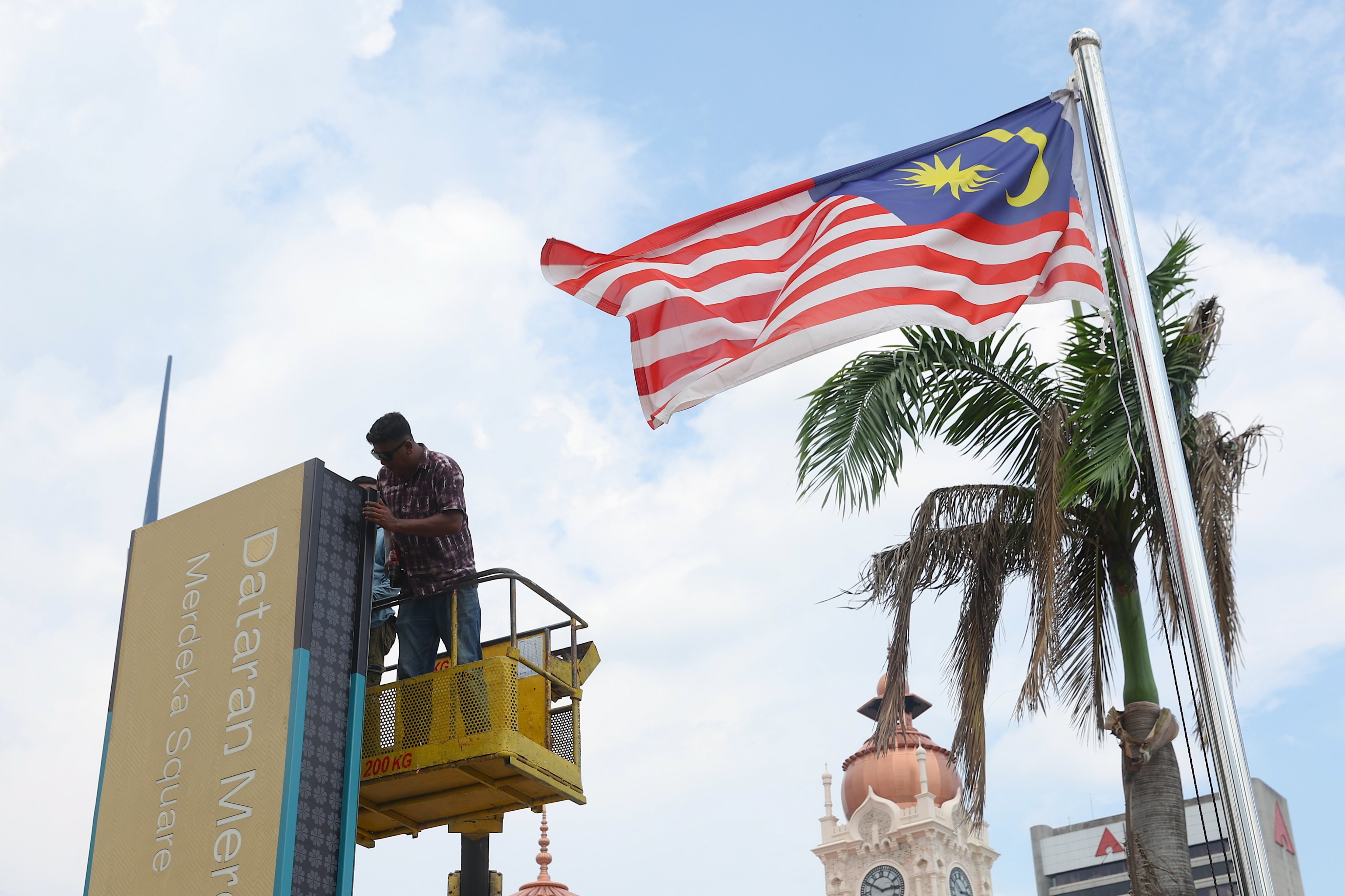 A worker repairs a signboard at Merdeka Square in Kuala Lumpur, Malaysia, on May 12. Photo: EPA