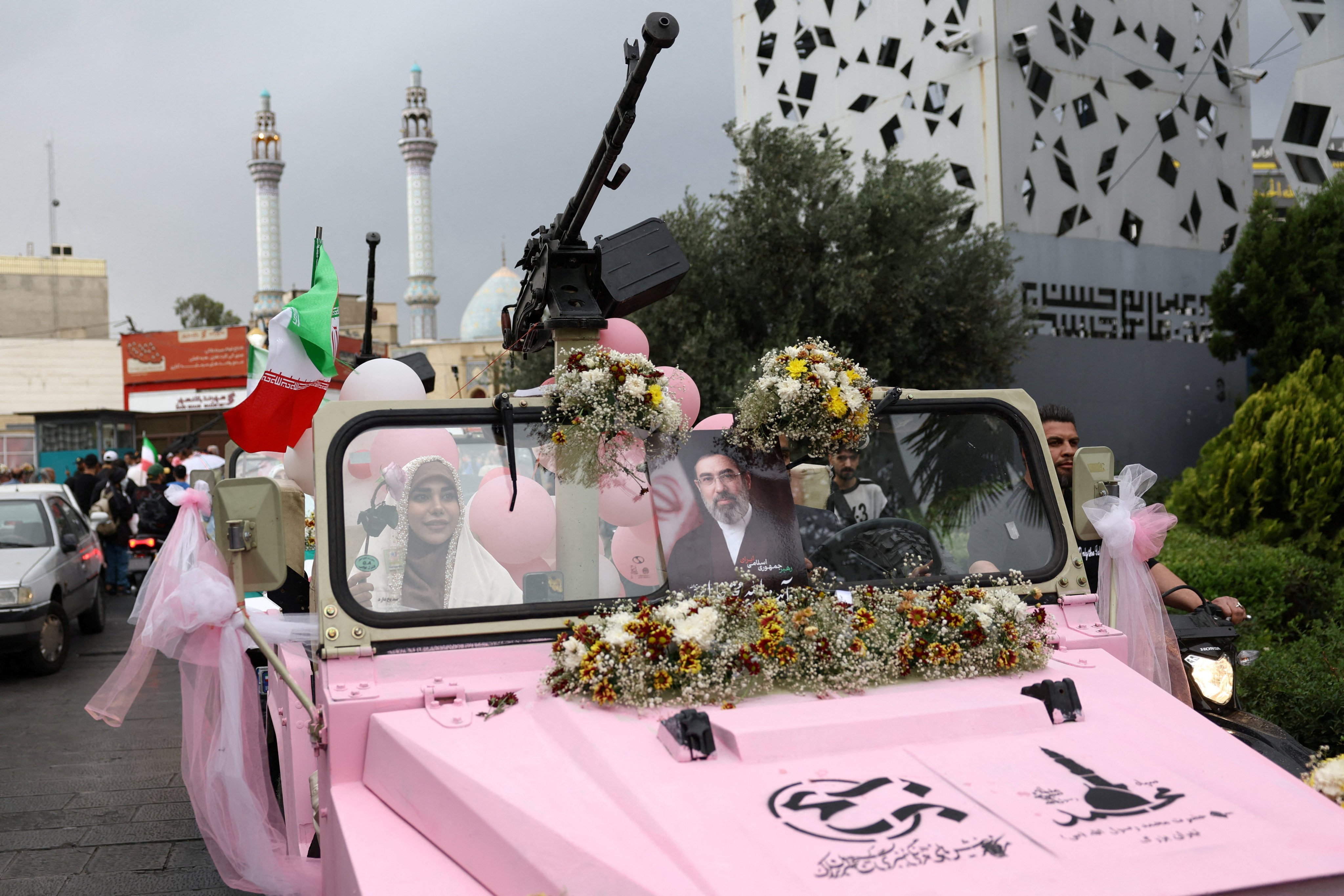 An Iranian couple arrive on a military vehicle for a “Sacrificed couple wedding” in Tehran on Monday. Photo: West Asia News Agency/Reuters
