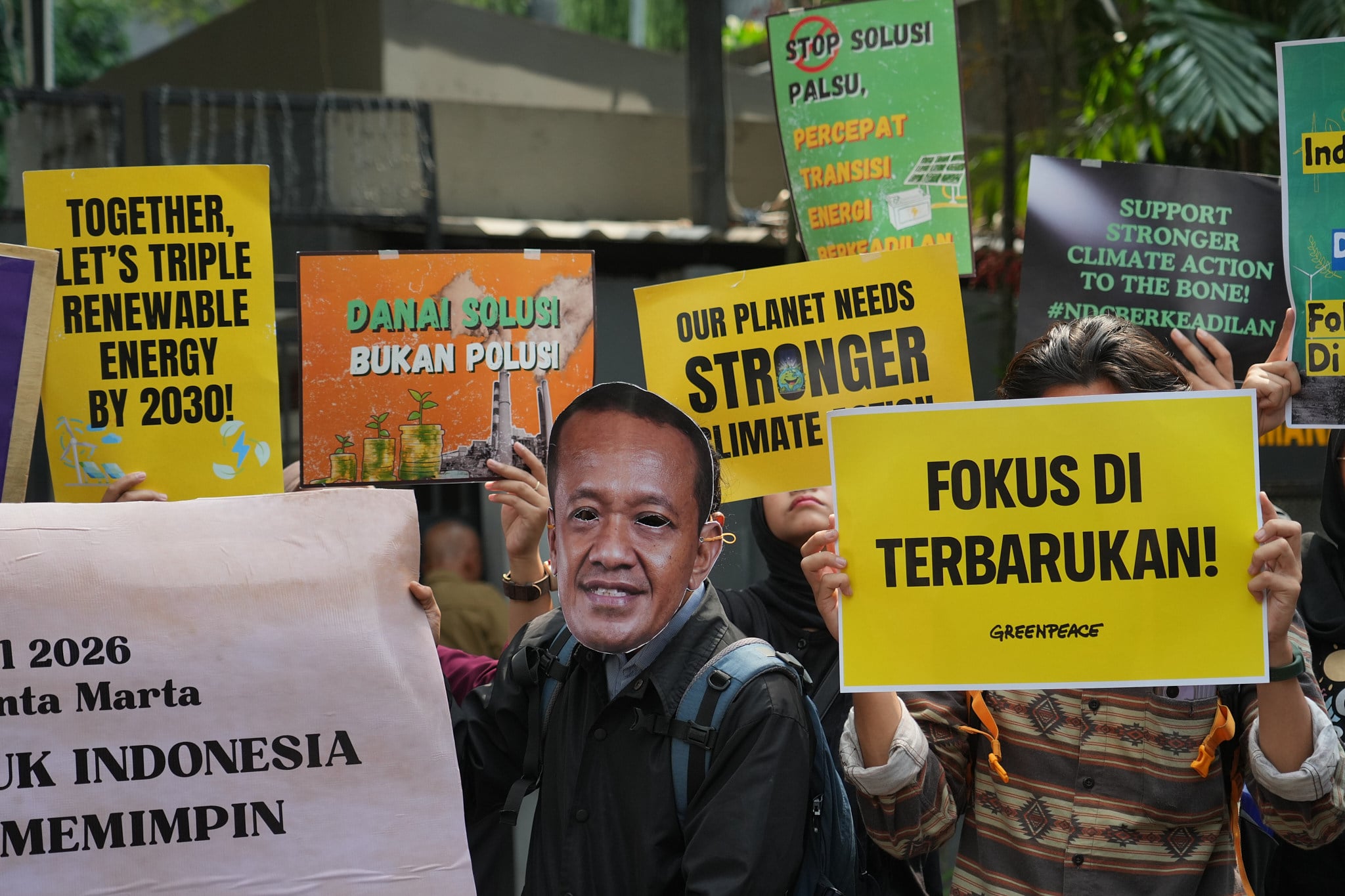 An Indonesian protester wearing a mask of Energy Minister Bahlil Lahadalia poses with others during a rally marking Earth Day outside the ministry office in Jakarta last month. Photo: AP