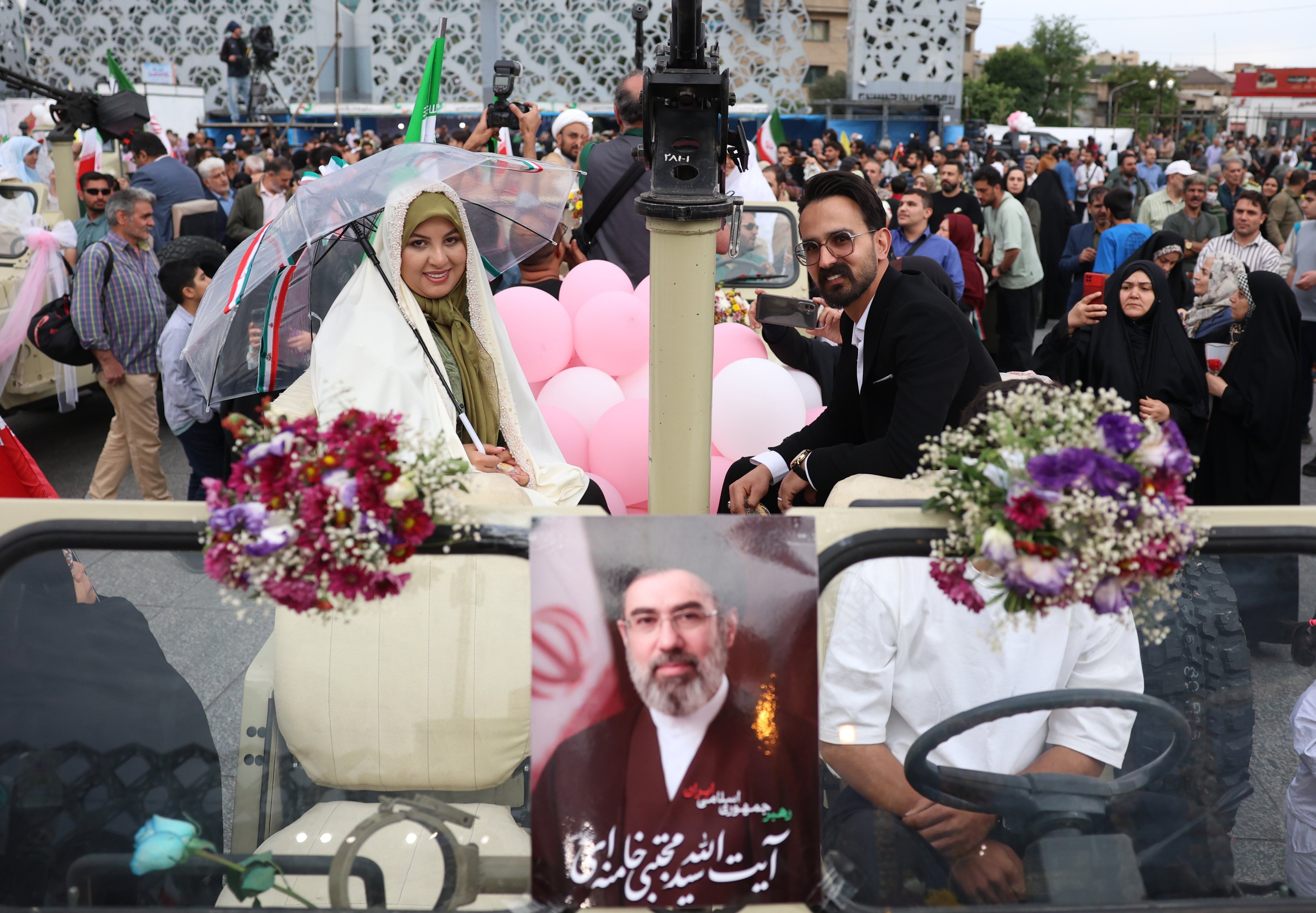 An Iranian bride and groom arrive on a military vehicle during a “janfada” mass wedding ceremony on Monday. Photo: EPA