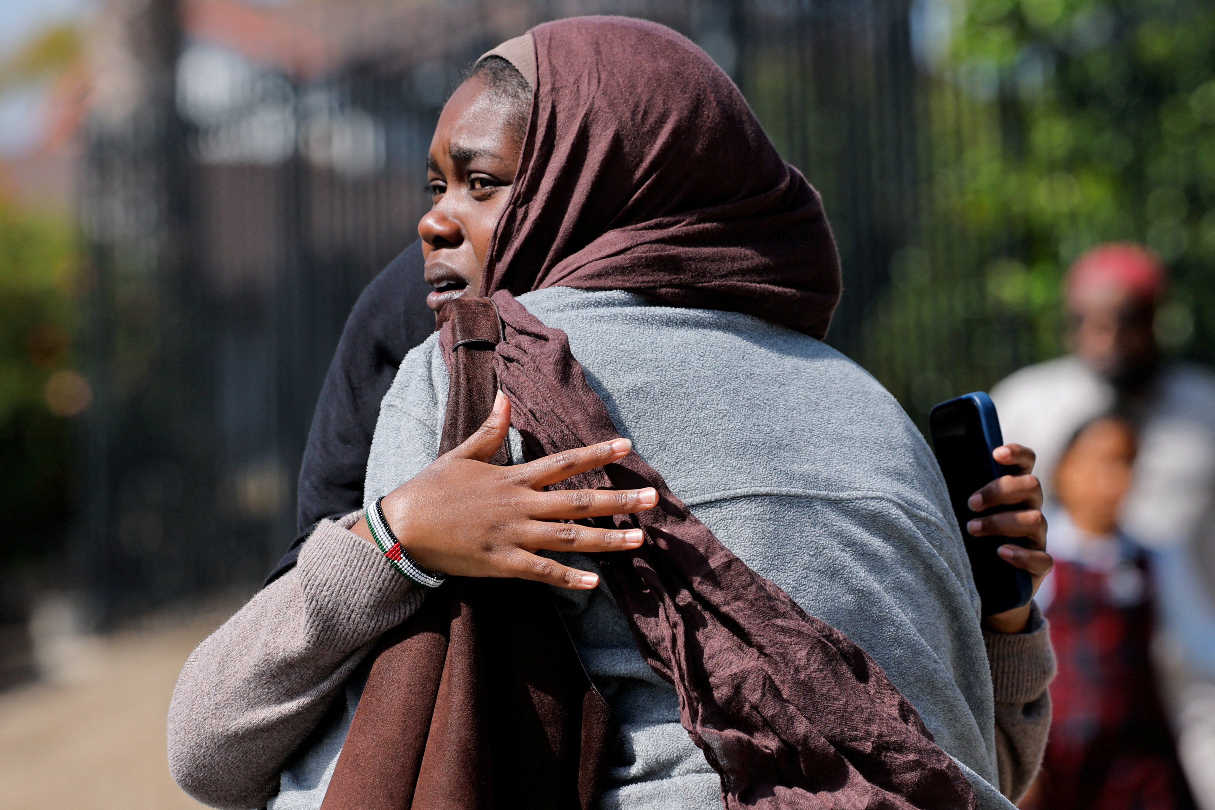 Women hug as they wait for the children to walk out of the mosque, the scene of the shooting. Photo: Reuters