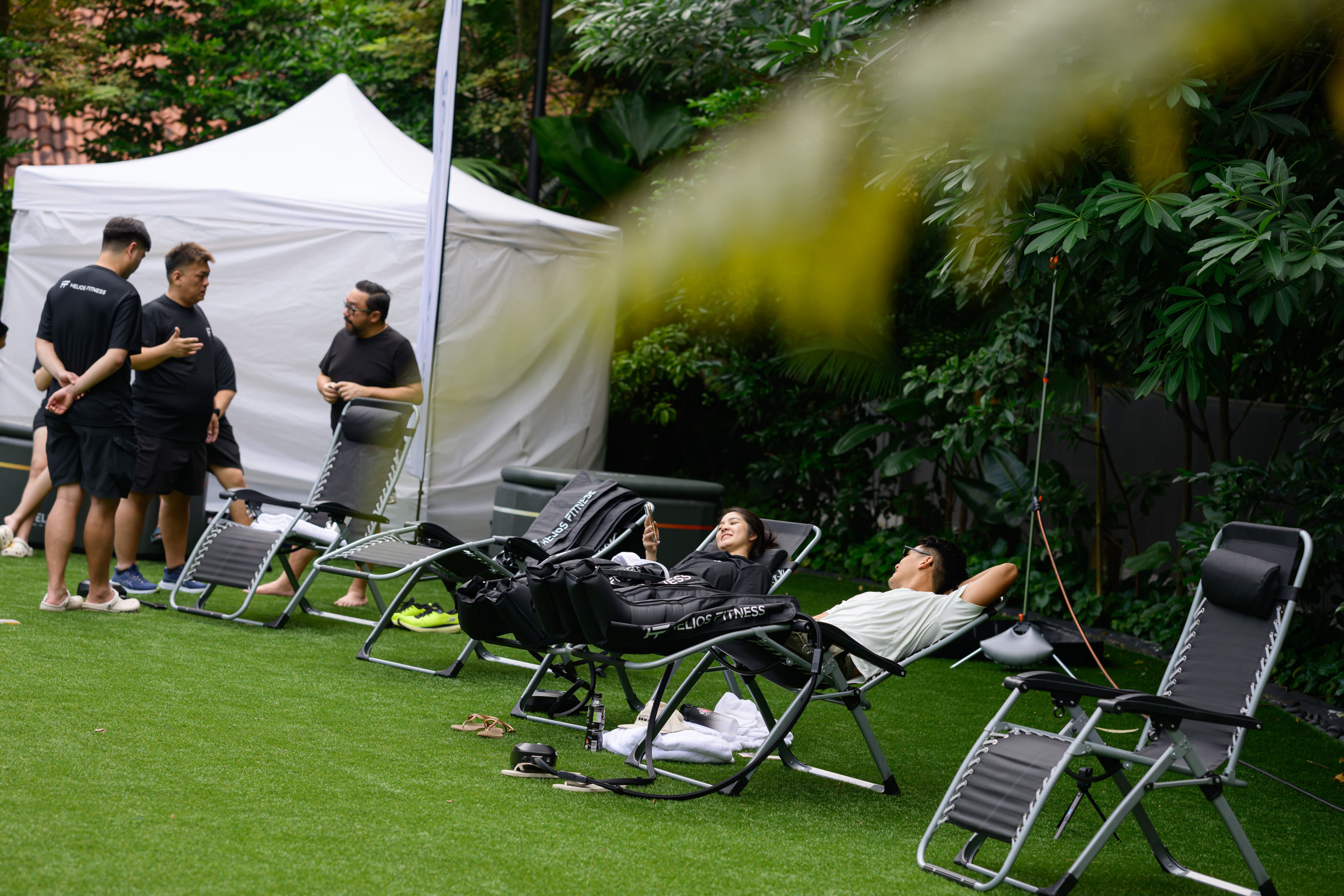 Leg compression helps improve circulation and flush out toxins, enhancing post-race recovery. Here, racers relax at Grand Hyatt Singapore’s Hyrox recovery event, Oasis Escapes. Photo: Handout