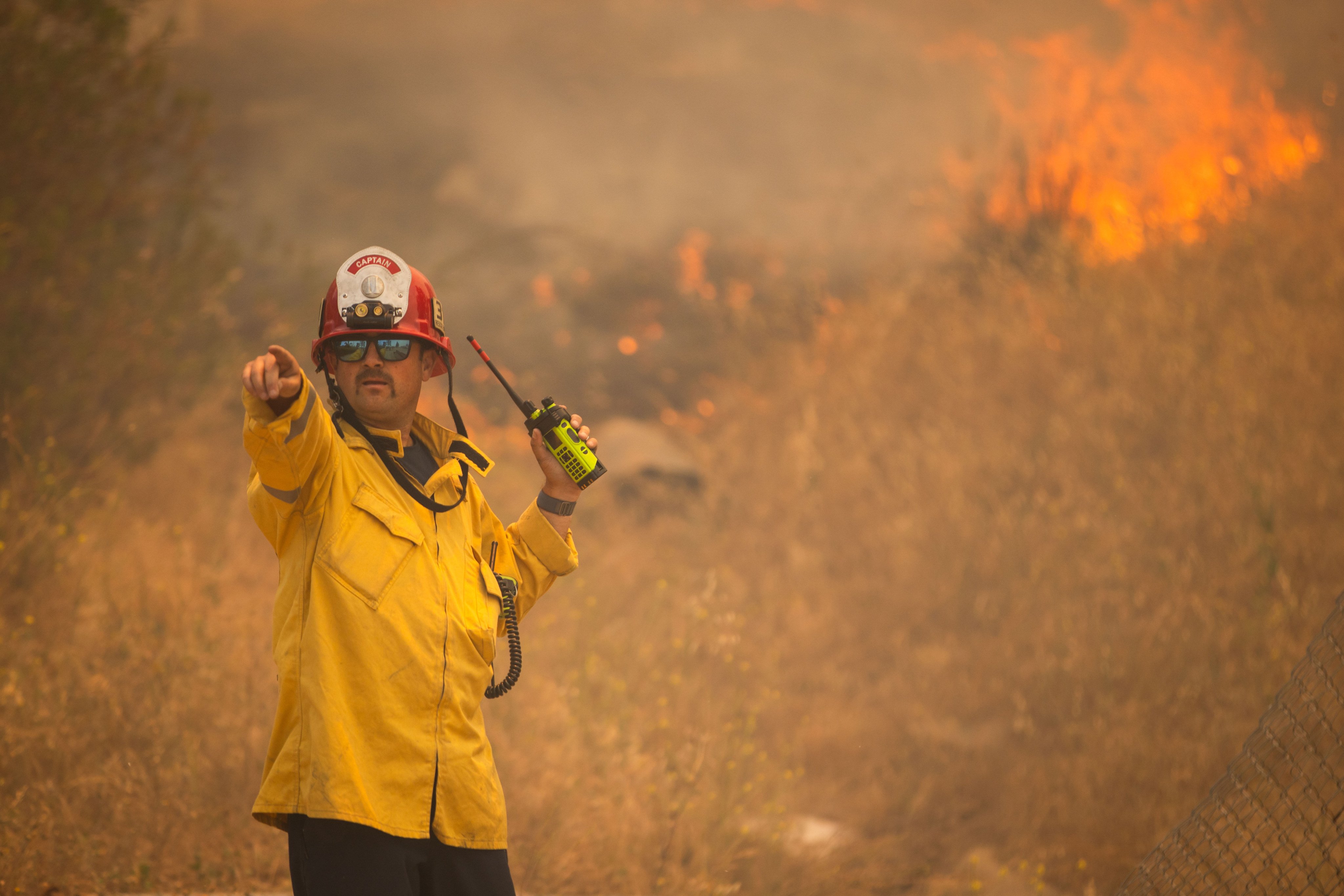 A firefighter points as the Sandy Fire approaches a neighbourhood in Simi Valley, California on Monday. Photo: AP