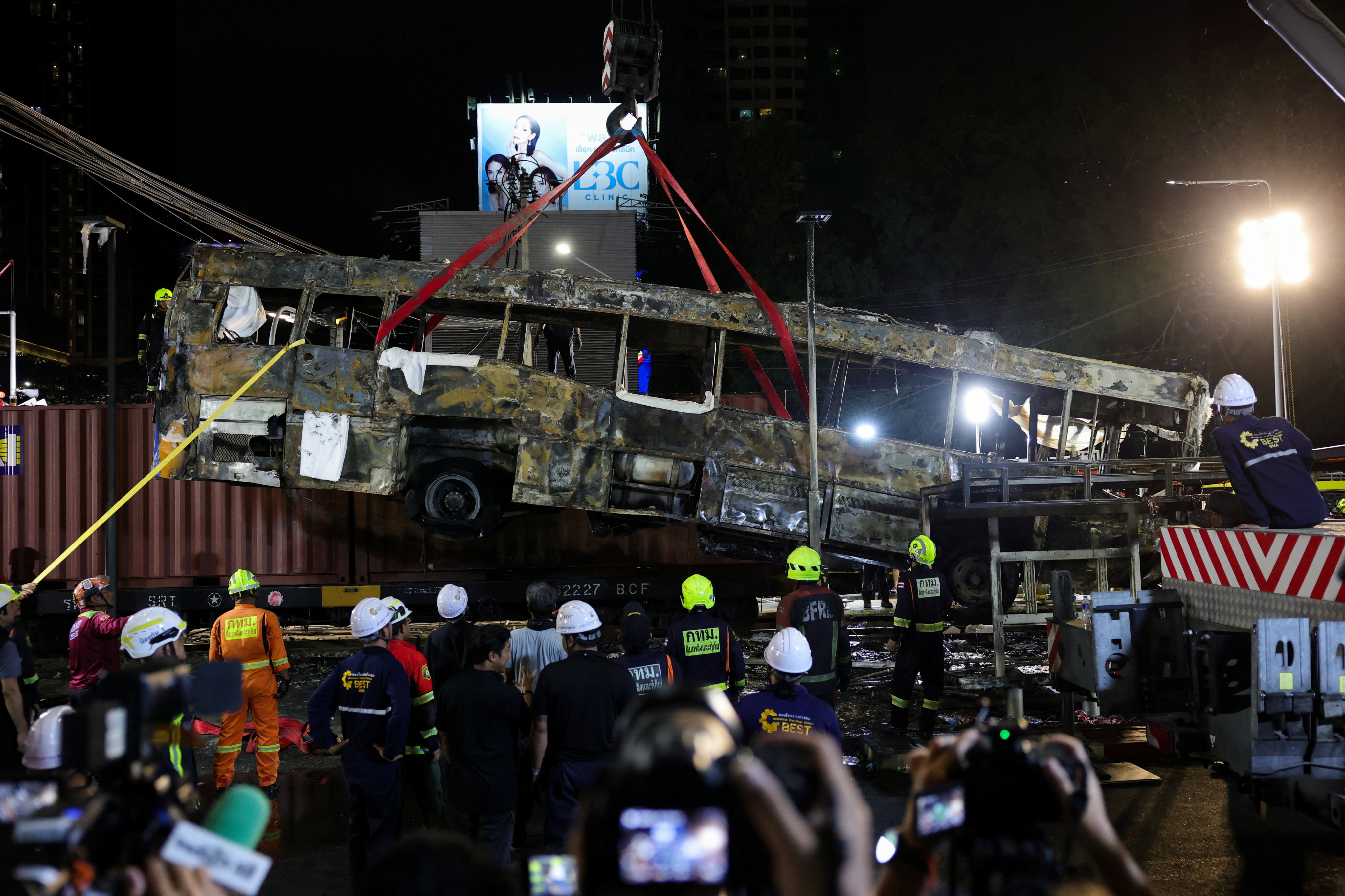 A crane lifts a bus that collided with a train and several cars on Asok-Din Daeng Road, causing several casualties, in Bangkok, Thailand, on May 16. Photo: Reuters