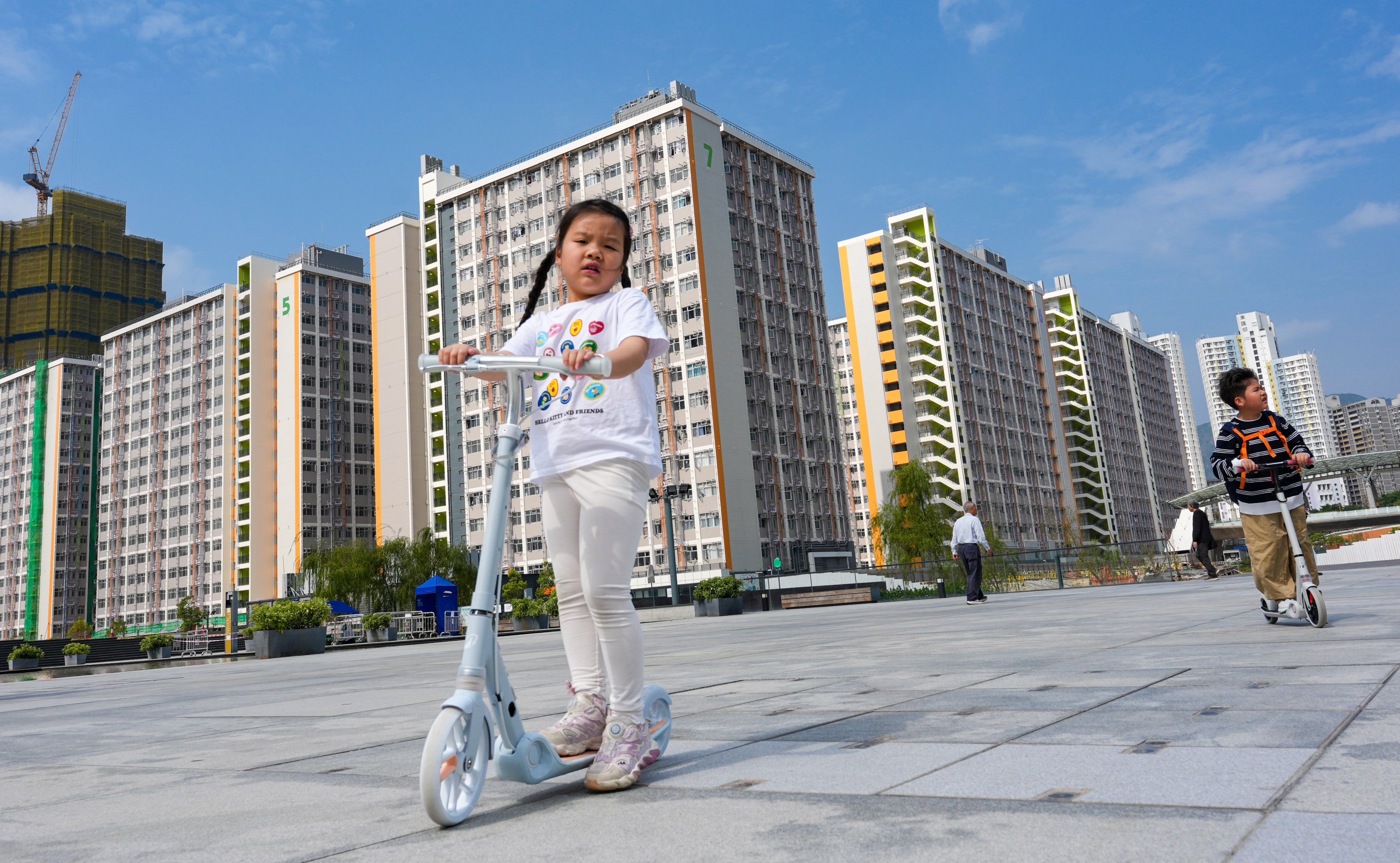 Children ride scooters on the grounds of the Kai Tak Light Public Housing development on February 23. Photo: Jelly Tse