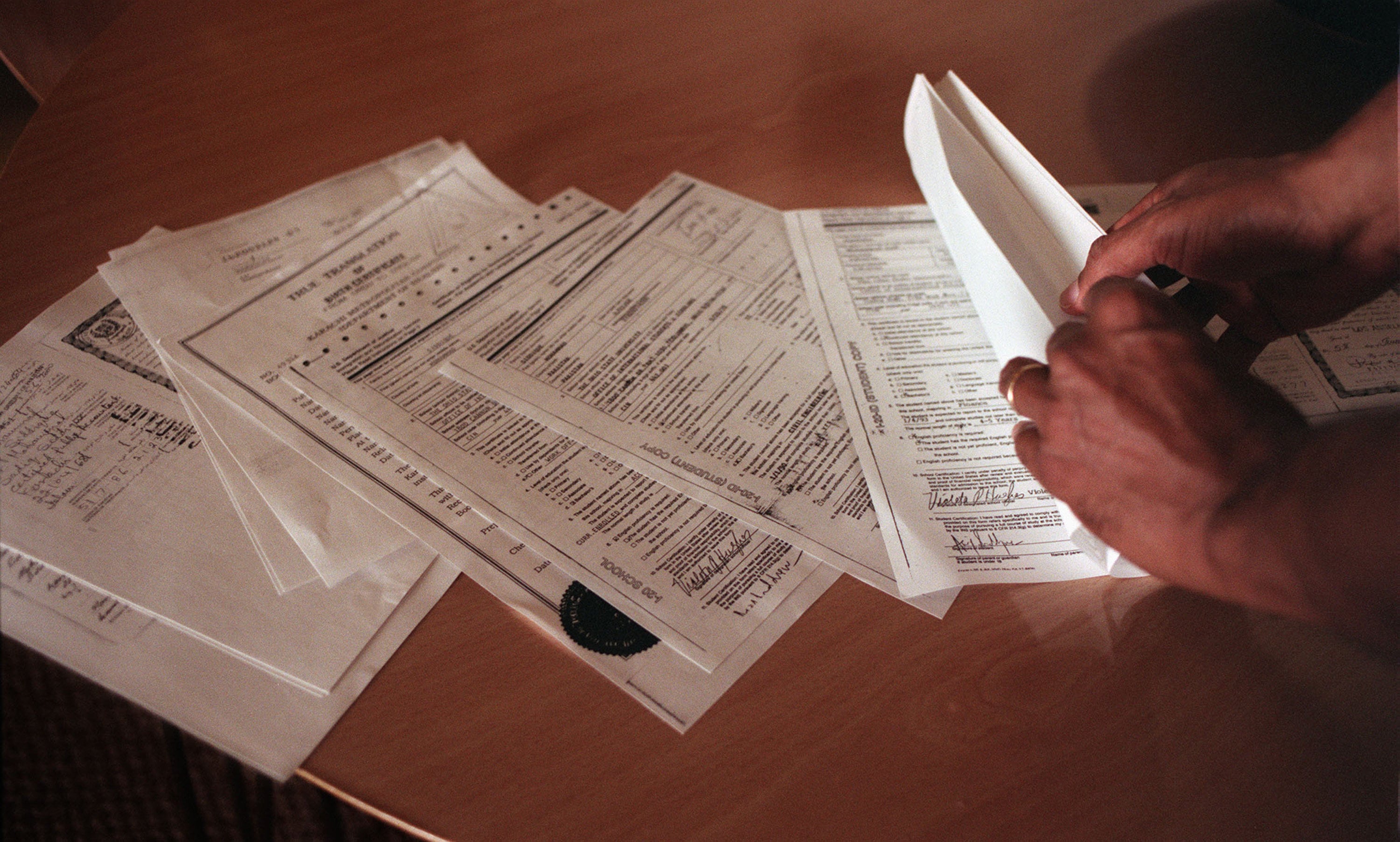 An applicant looks through H-1B visa application documents. Last year, Washington raised the H-1B application fee to US$100,000. Photo: Bay Area News Group/TNS