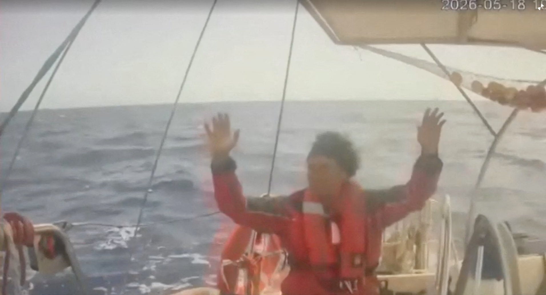 A man on board the Global Sumud Flotilla raises his hand as an Israeli naval boat intercepts the flotilla on Monday. Photo: Global Sumud Flotilla/Reuters