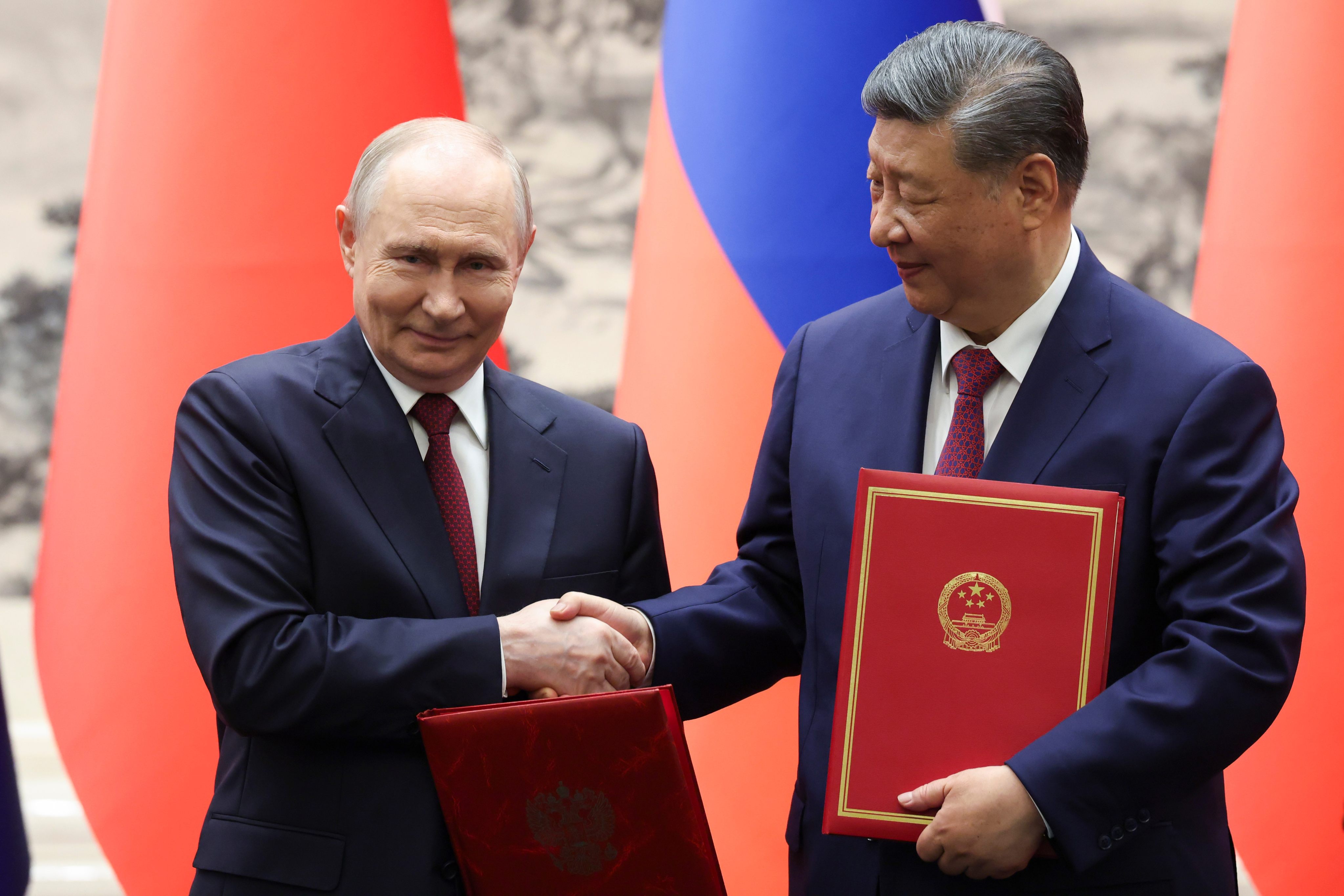 Russian President Vladimir Putin and Chinese President Xi Jinping shake hands during a signing ceremony at the Great Hall of the People. Photo: Pool via AP
