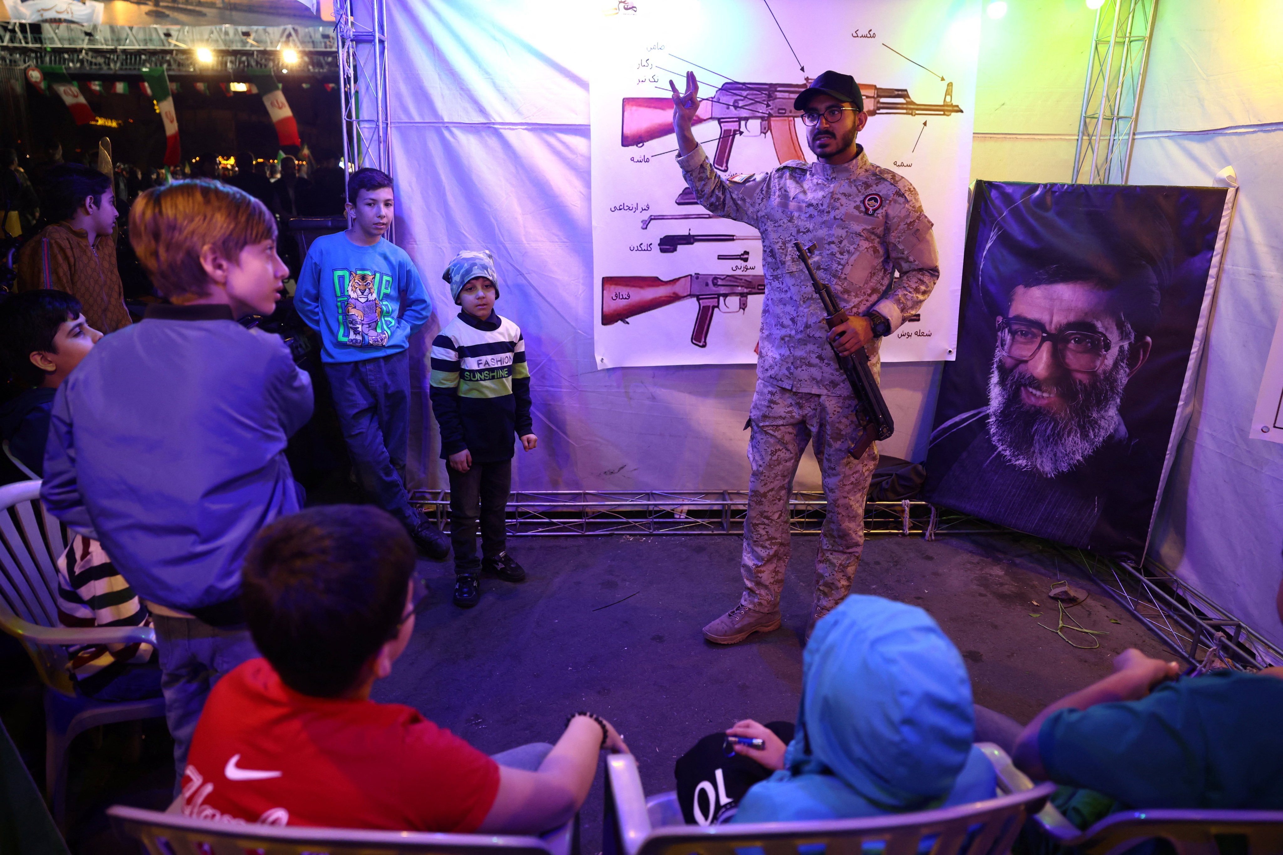 An Iranian military member gives a talk on guns at a booth in Hafte Tir Square, in Tehran on Monday. Photo: WANA/Reuters