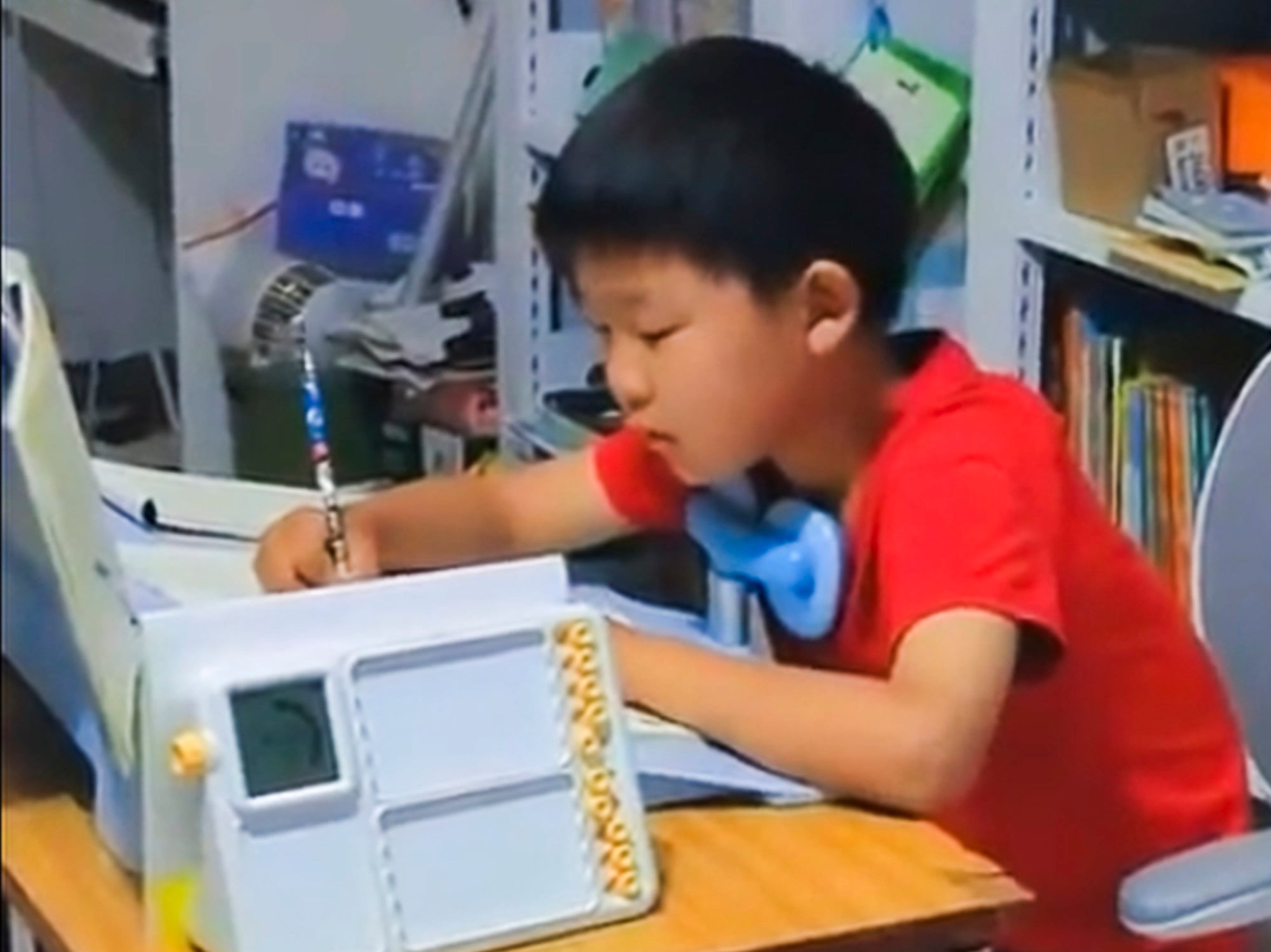 The boy focuses hard as he writes at his converted desk. His mother says her son’s performance has improved. Photo: Weibo The boy focuses hard as he writes at his converted desk. His mother says her son’s performance has improved. Photo: Weibo
