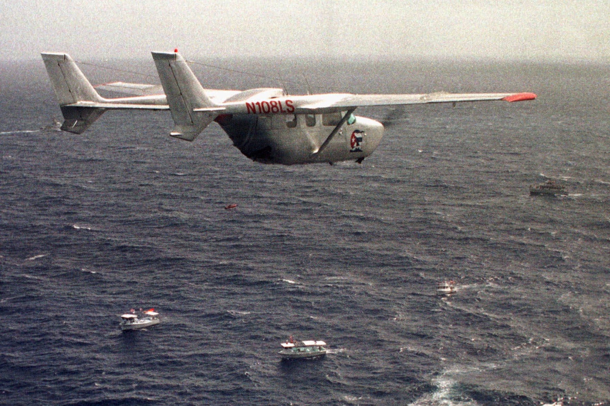 A Brothers to the Rescue plane flies over The Democracy Movement flotilla at the ‘12-mile limit’ north of Havana, Cuba, July 10, 1999. Photo: AP
