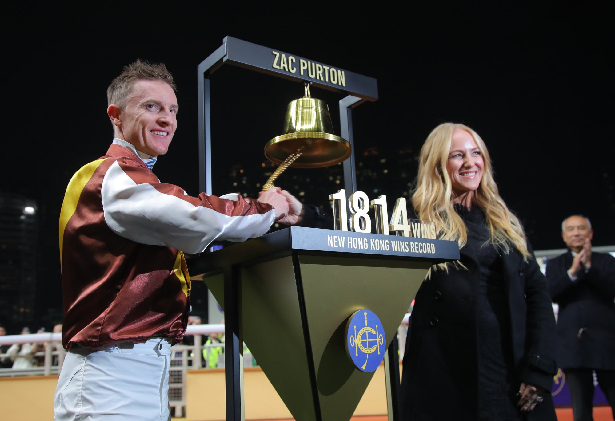Zac Purton and wife Nicole ring the commemorative bell after Purton broke Douglas Whyte’s all-time Hong Kong record.