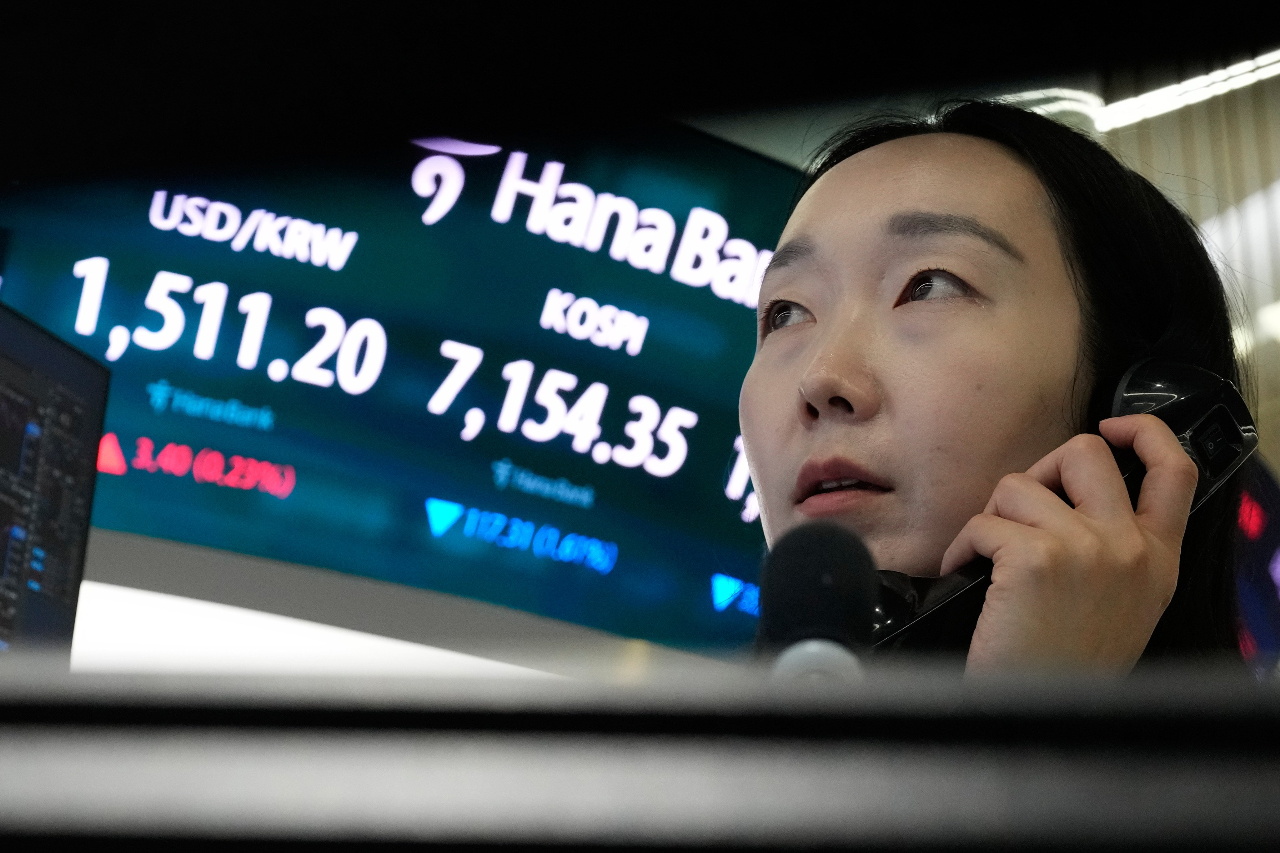 A currency trader talks on the phone near a screen showing the Korea Composite Stock Price Index and the foreign exchange rate between the US dollar and South Korean won at the foreign exchange dealing room of the Hana Bank headquarters in Seoul on May 20. Photo: AP