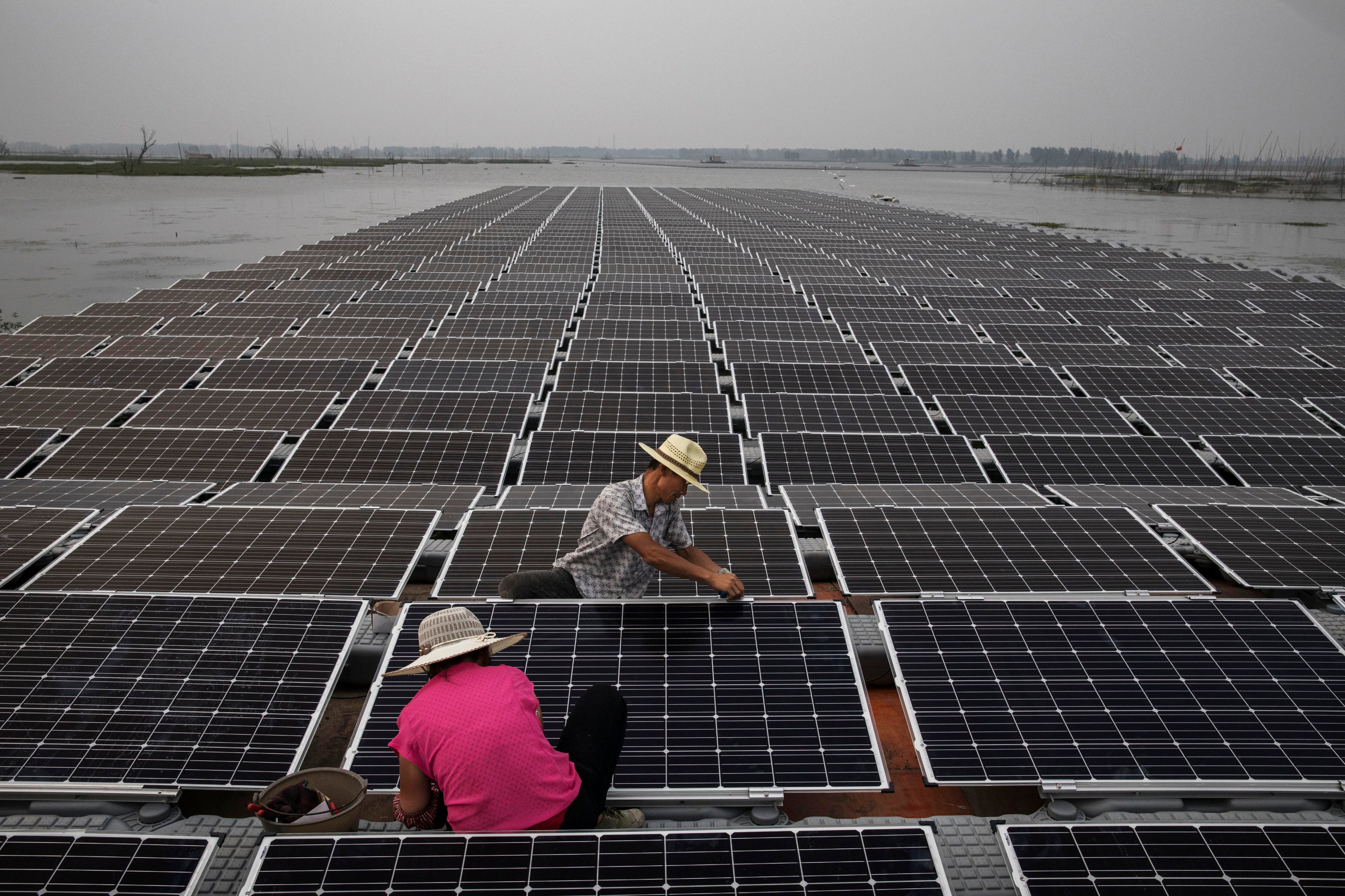 Chinese workers prepare  panels that will be part of a large floating solar farm project in the central Anhui province. Photo: Getty Images