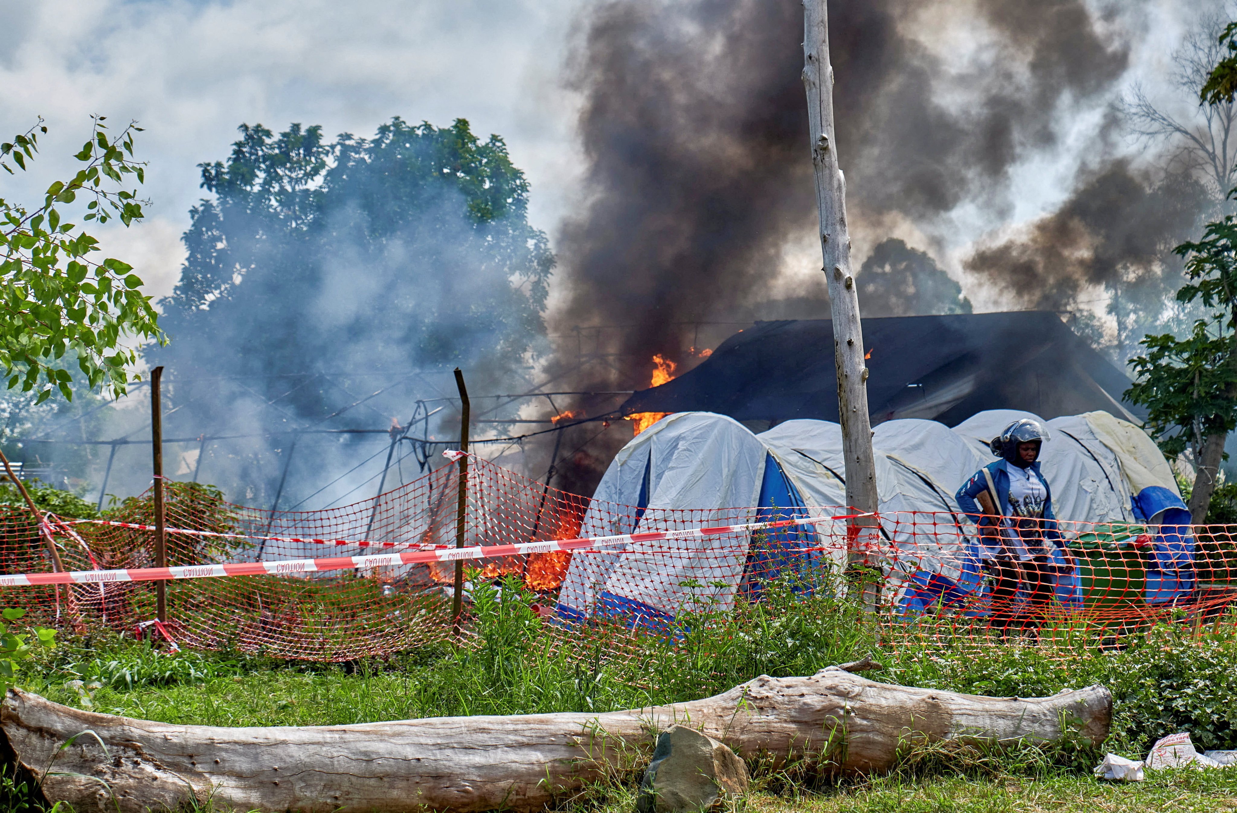 A Congolese police officer stands guard at a burning Ebola treatment centre in Rwampara, outside Bunia, Ituri province, Democratic Republic of Congo on Thursday. Photo: Reuters