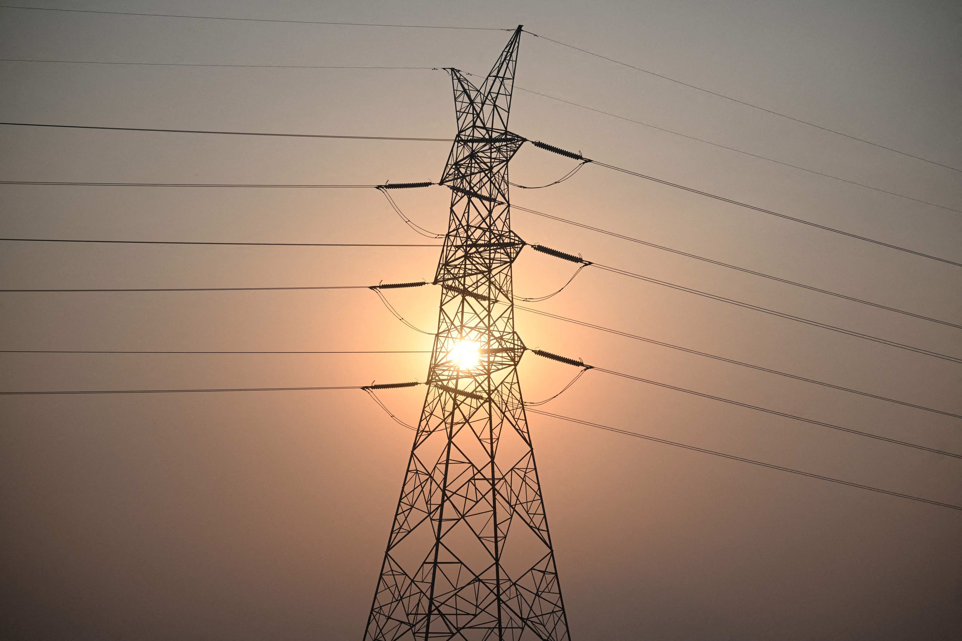 The sun sets behind power lines in San Fernando town, Pampanga province, the Philippines, last month. Photo: AFP