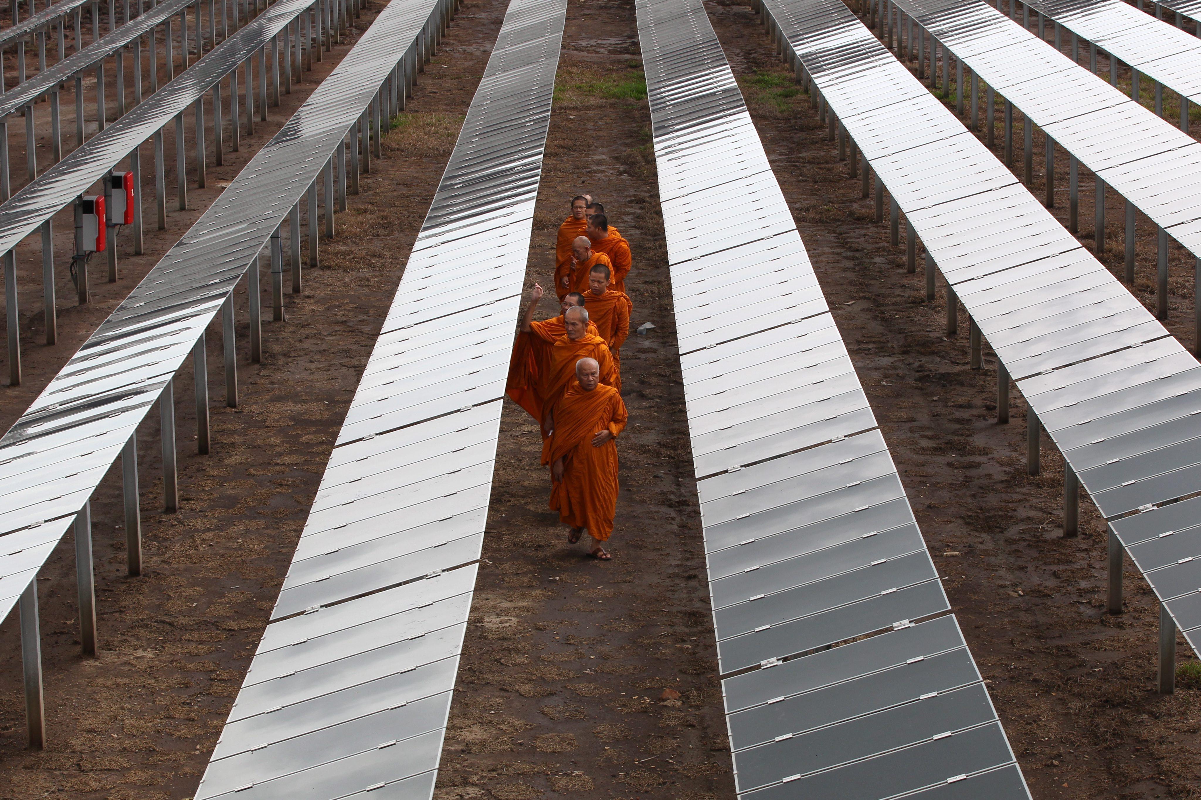 Buddhist monks walk through a solar park in Thailand in 2011. Photo: EPA
