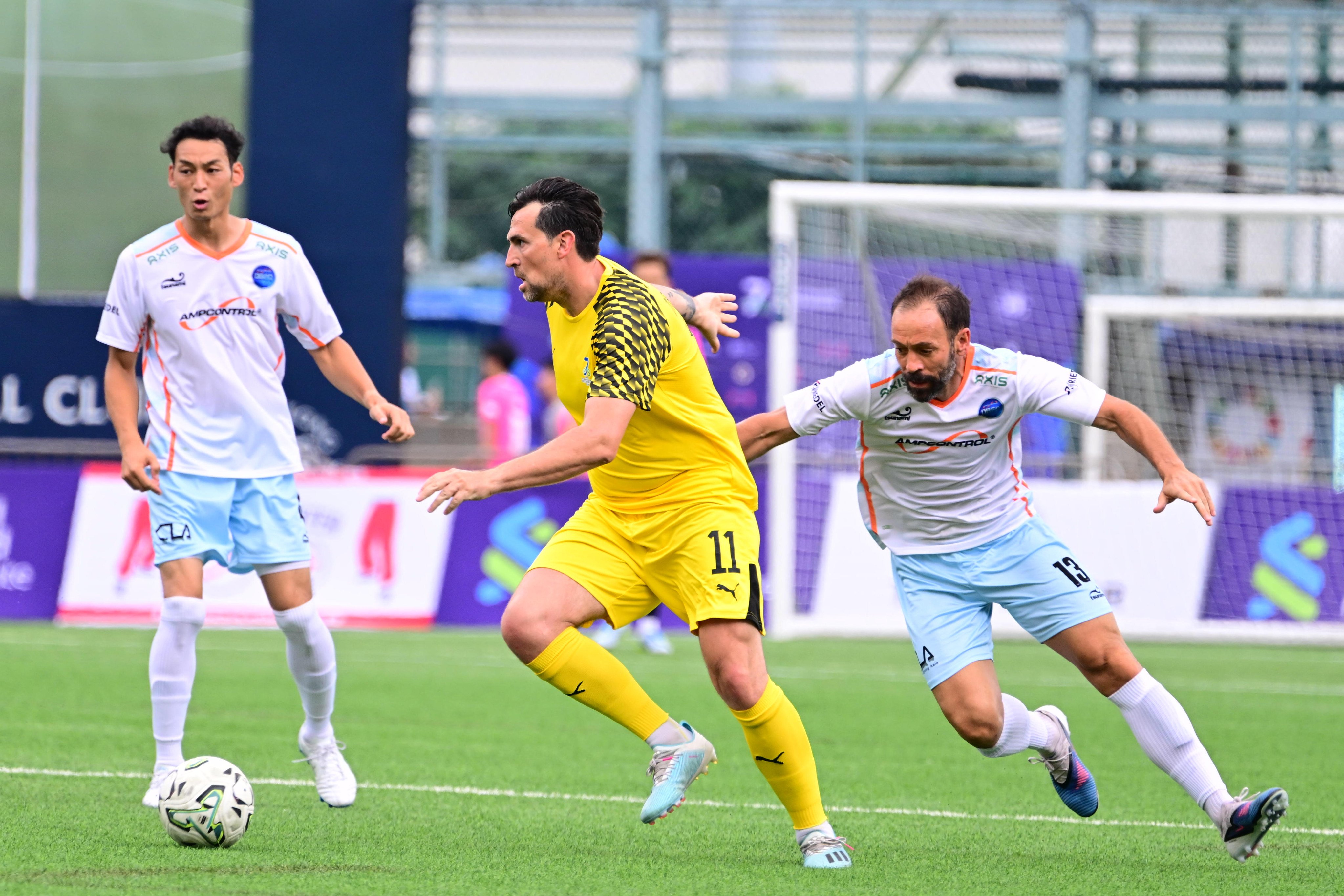 Charlie Daniels tries to escape the clutches of Inigo Calderon, the Kitchee head coach playing for Ampcontrol Discovery Bay. Photo: HKFC
