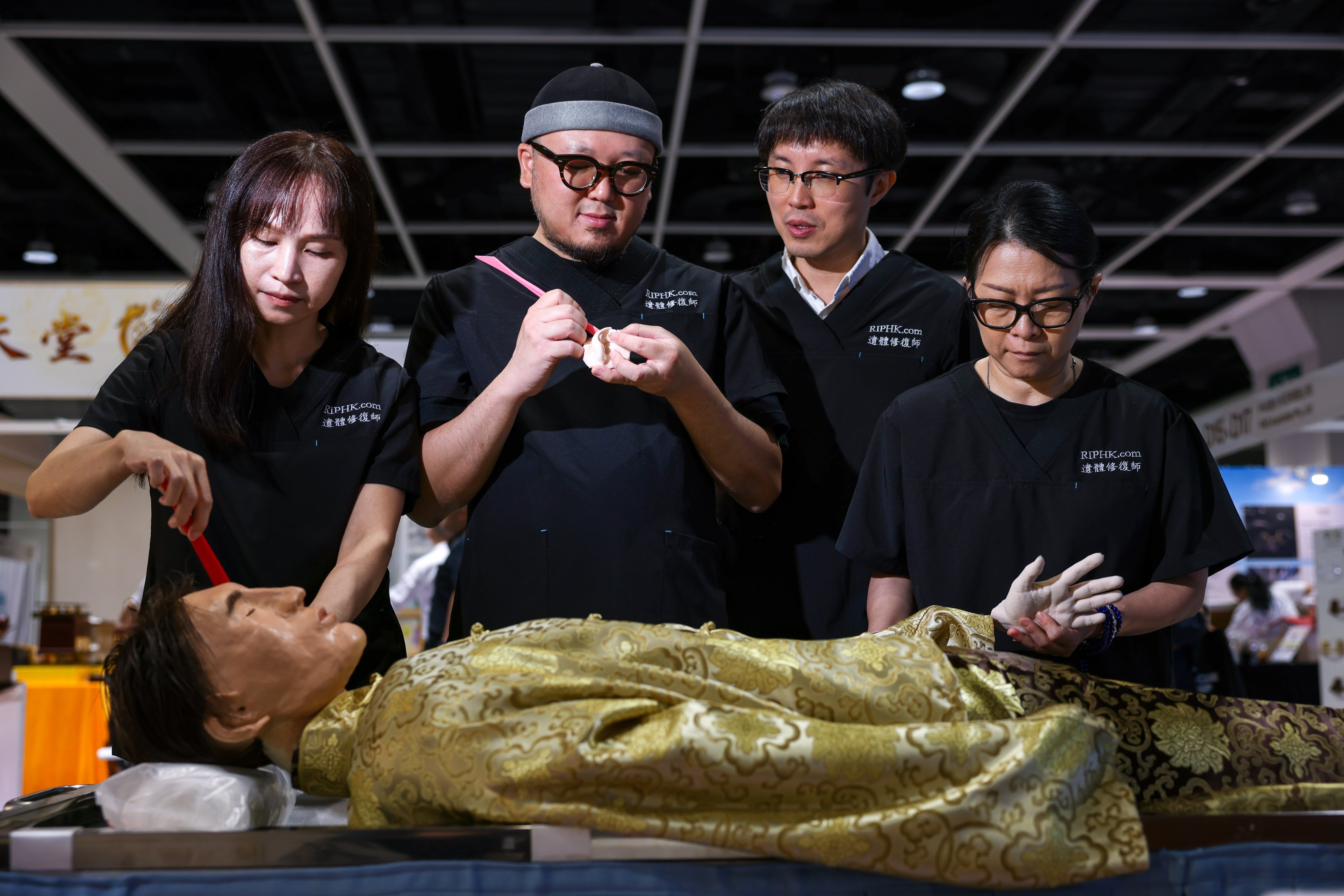 Hong Kong’s first corpse restoration team include (from left) Renee Chan, Chan Yan, Bryan Kam and Vangie Lee, photographed with a dummy corpse at the Asia Funeral and Cemetery Expo & Conference earlier this week. Photo: Nora Tam