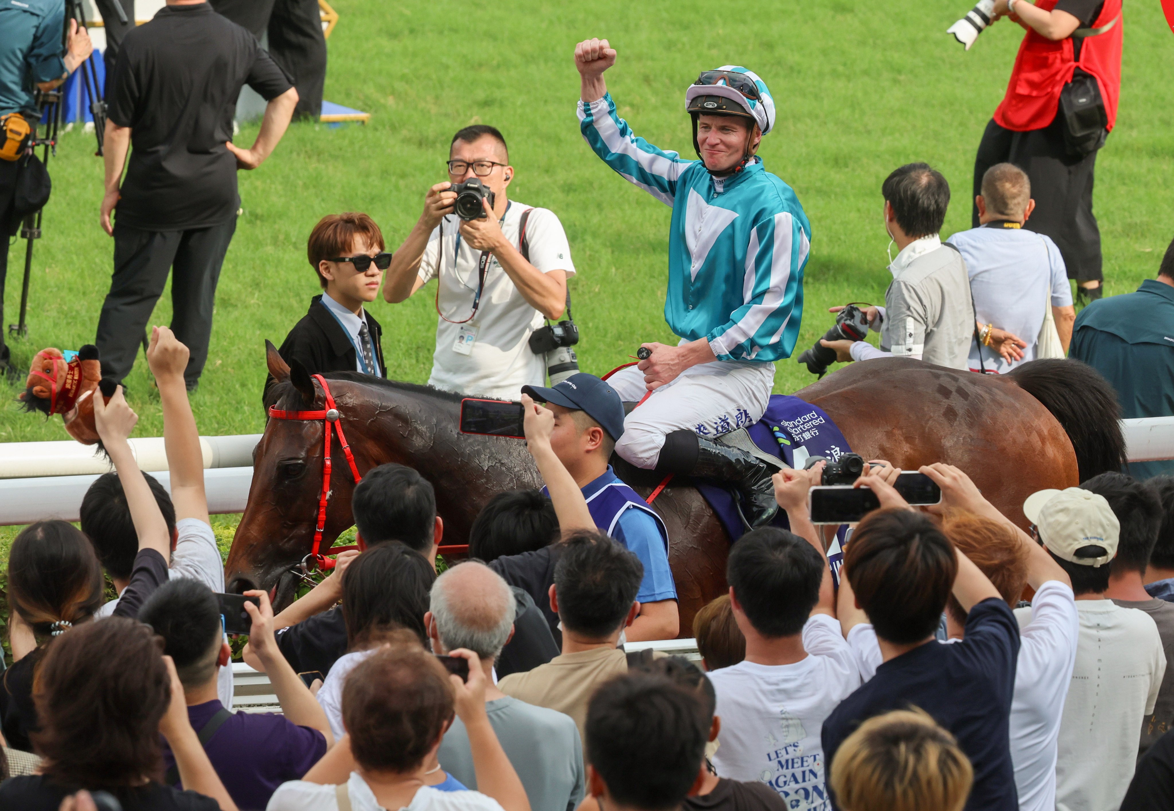 Jockey James McDonald salutes the crowd after guiding Romantic Warrior to victory in the Champions & Chater Cup. Photo: Dickson Lee