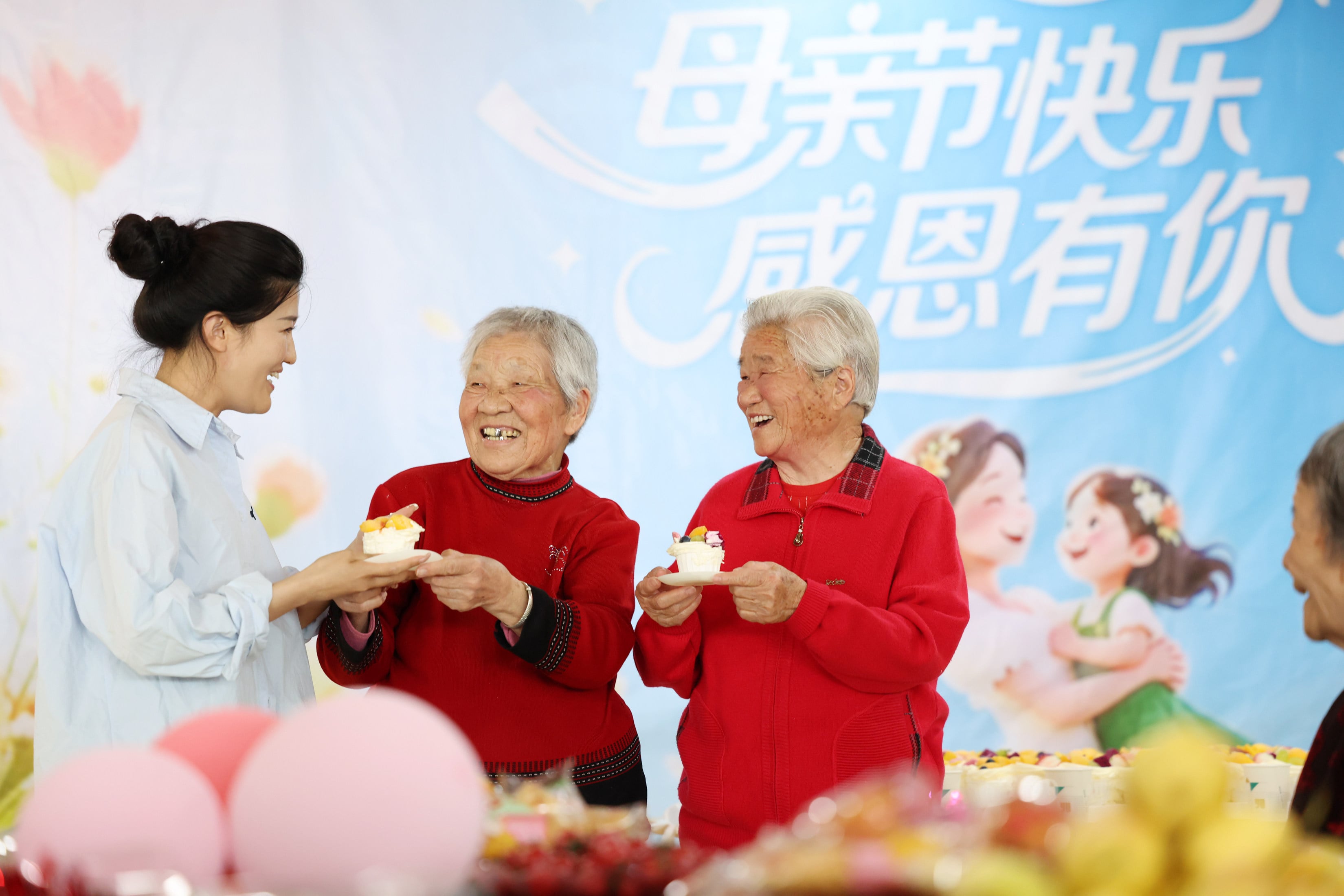 A staff member serves cakes to two women at an elderly care service centre in Linyi, Shandong province, on May 10. Photo: Xinhua