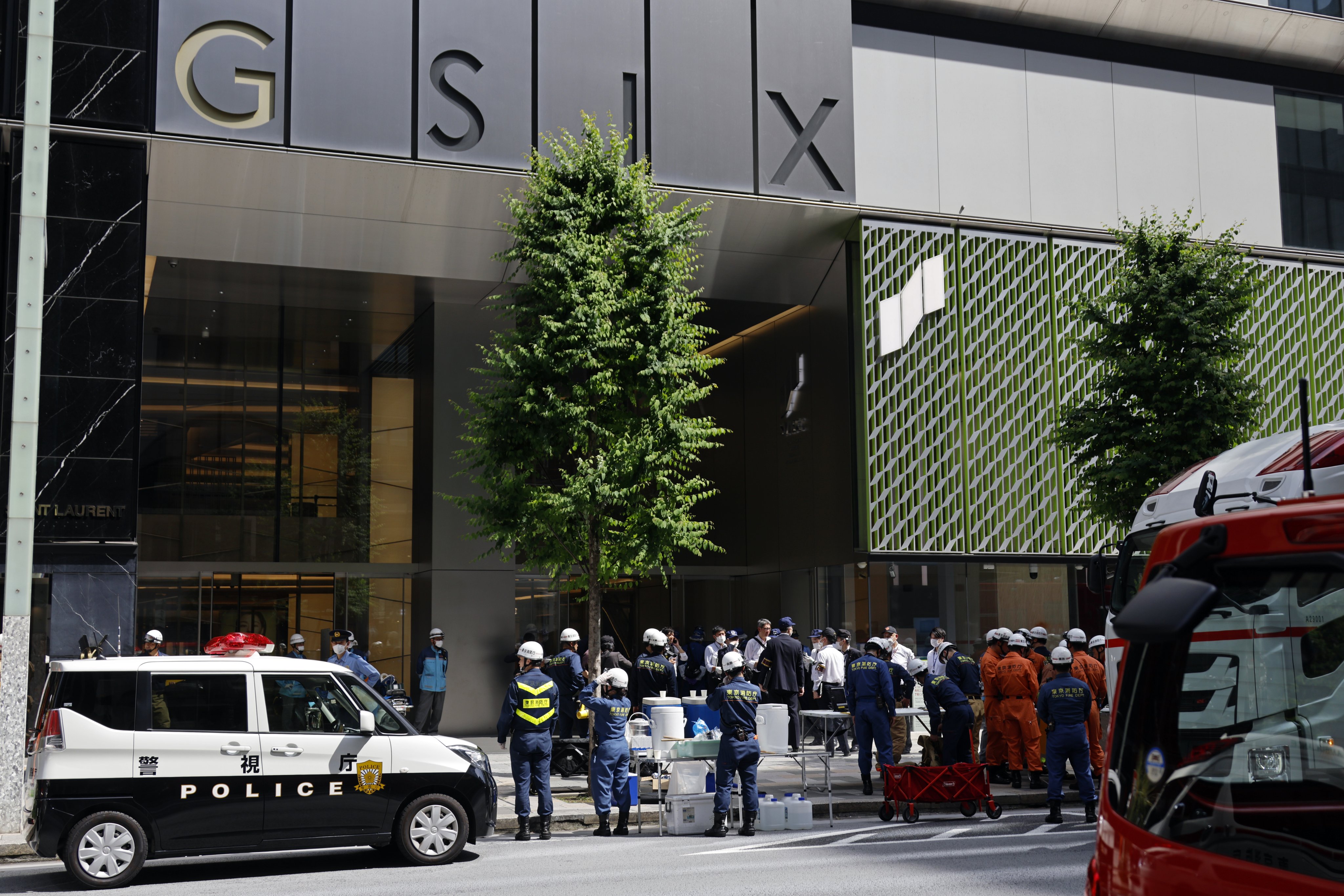 Firefighters and police officers stand in front of the Ginza Six luxury shopping centre in Tokyo’s Ginza district after a man allegedly sprayed a substance inside the mall on Monday. Photo: EPA