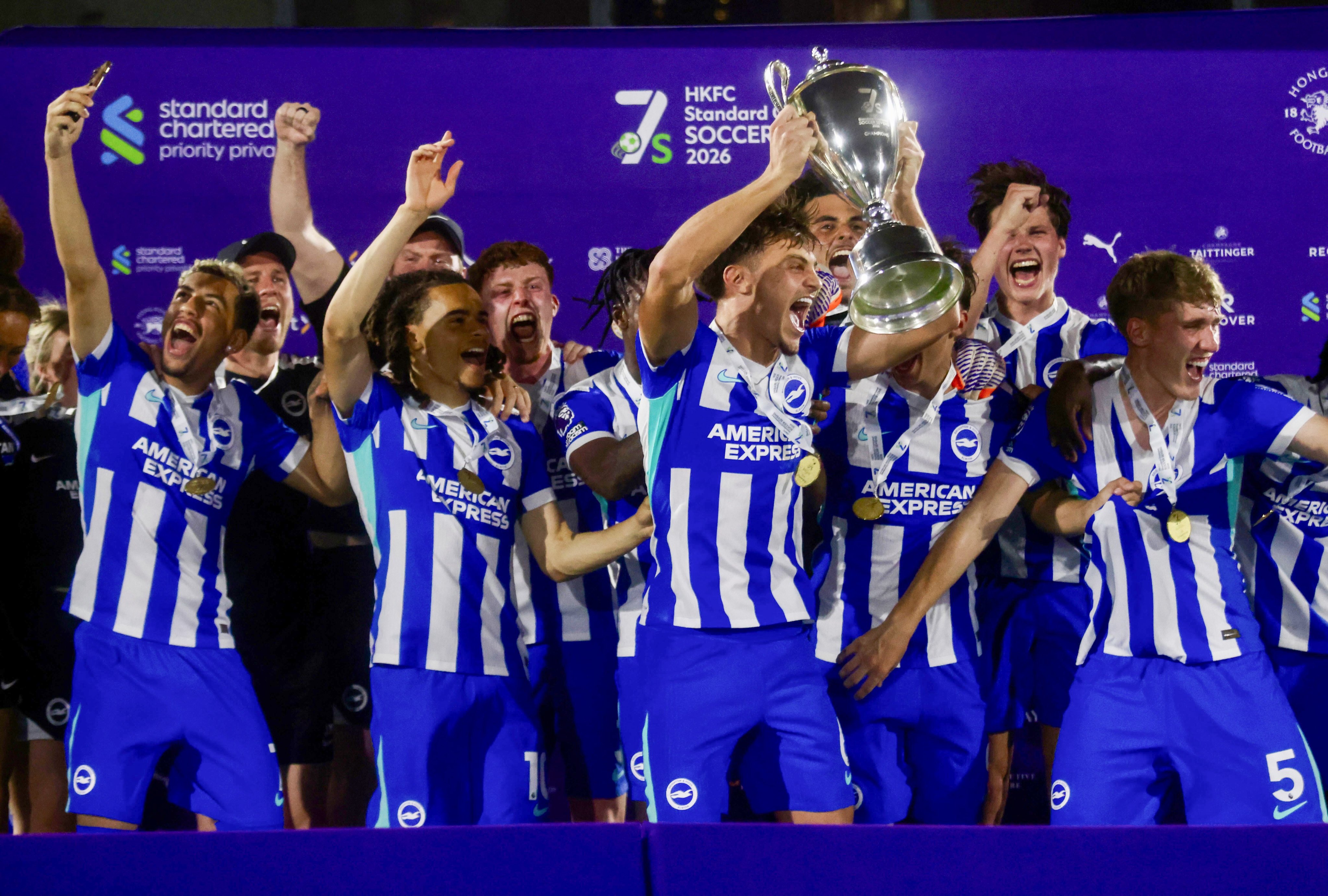 Captain Josh Robertson hoists the trophy and Tyler Silsby (far left) captures the moment, as Brighton celebrate their second Hong Kong success in three years. Photo: Jonathan Wong