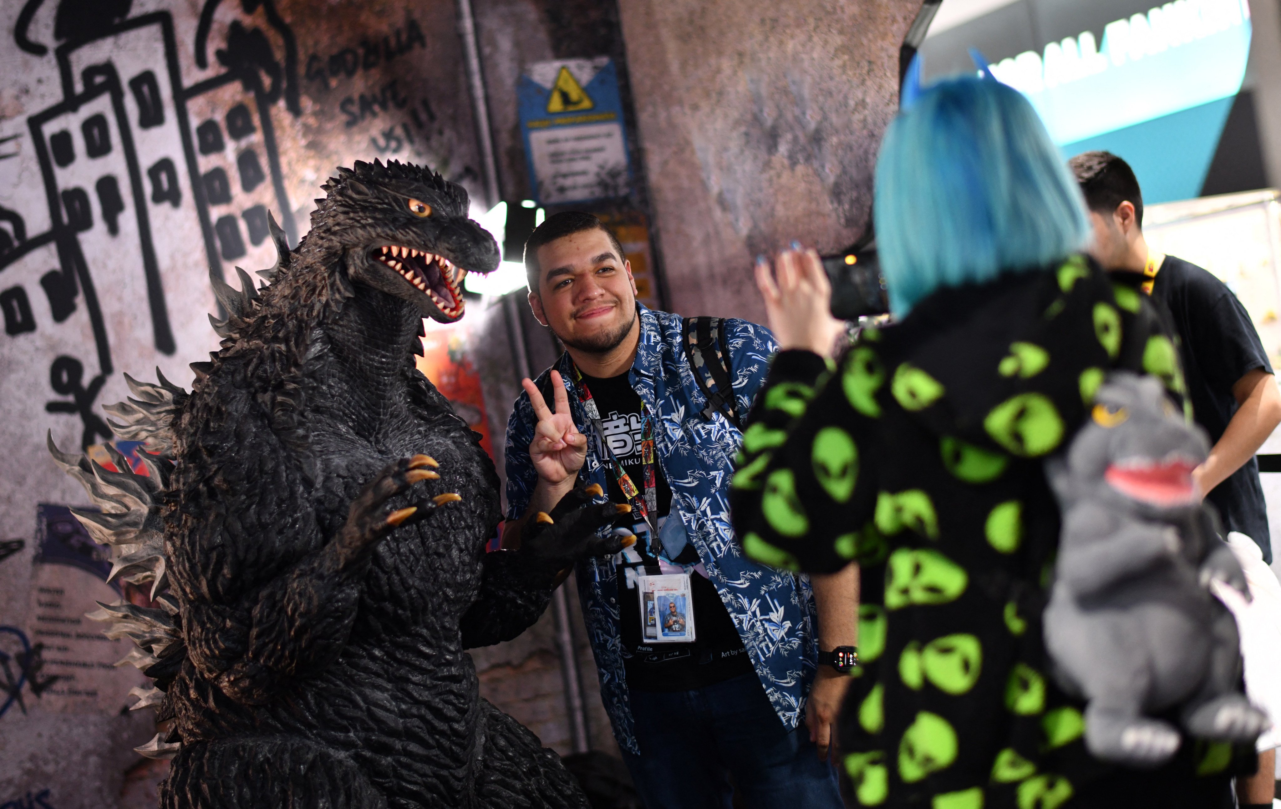 An attendee poses for photos with Godzilla during Comic-Con International in San Diego, California, on July 26, 2025. Photo: AFP